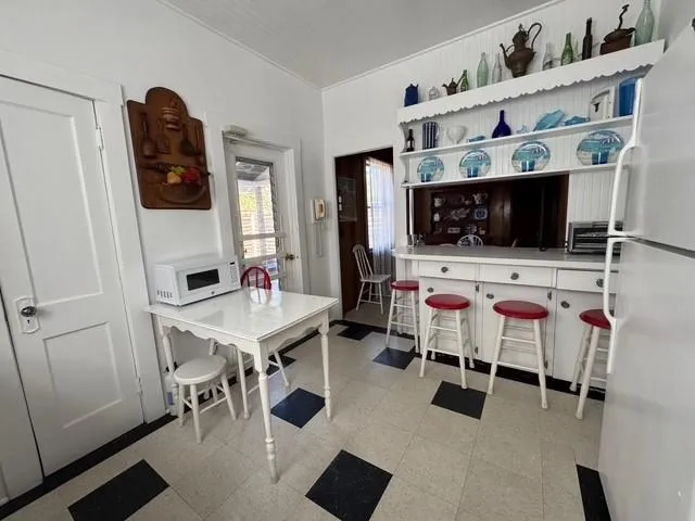 Kitchen featuring white appliances, open shelves, and light flooring Kitchen featuring white appliances, open shelves, and light flooring