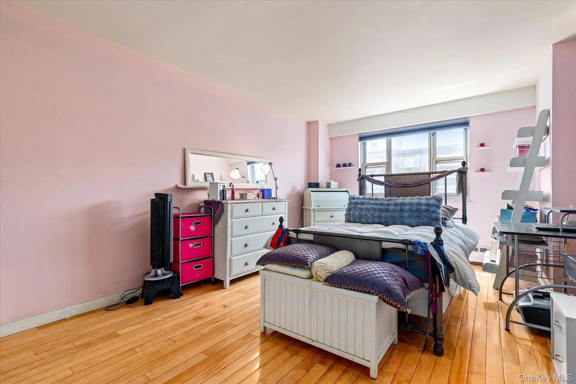 Bedroom with light wood-style floors and baseboard heating Bedroom with light wood-style floors and baseboard heating