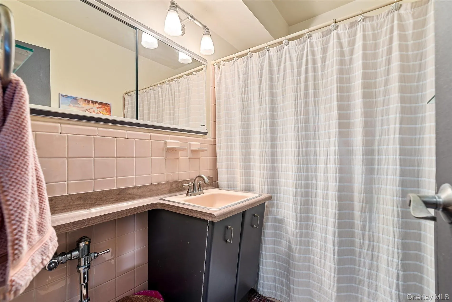 Full bath with vanity, decorative backsplash, tile walls, and a shower with curtain Full bath with vanity, decorative backsplash, tile walls, and a shower with curtain