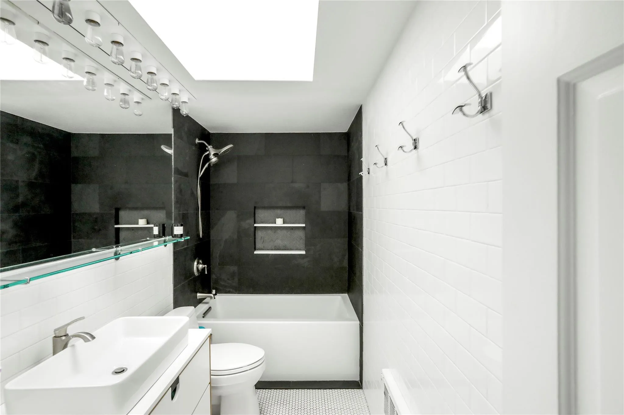 Full bathroom with tile walls, bathing tub / shower combination, toilet, and vanity Full bathroom with tile walls, bathing tub / shower combination, toilet, and vanity