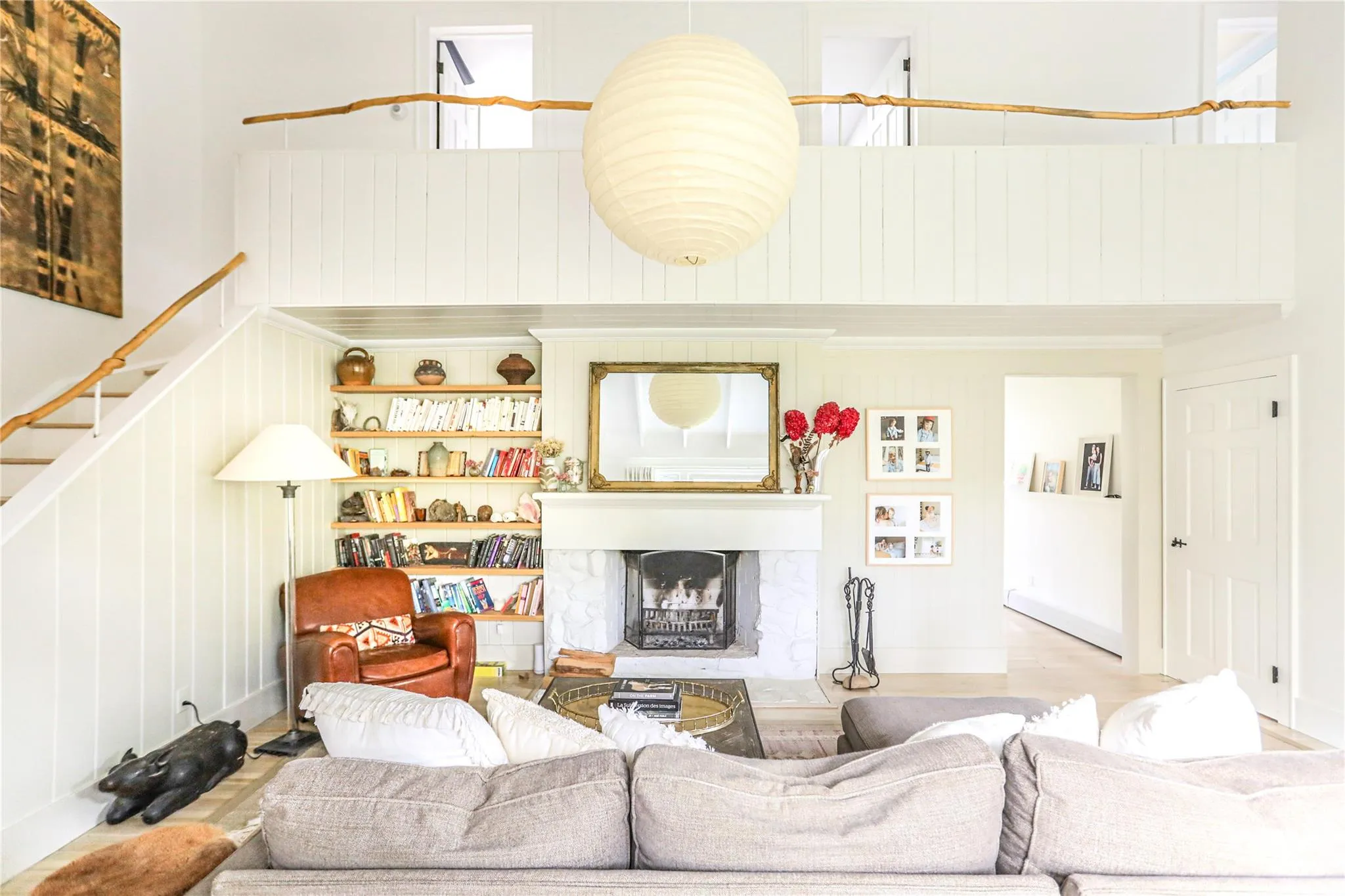 Living room with a towering ceiling, a fireplace with raised hearth, and wood finished floors Living room with a towering ceiling, a fireplace with raised hearth, and wood finished floors