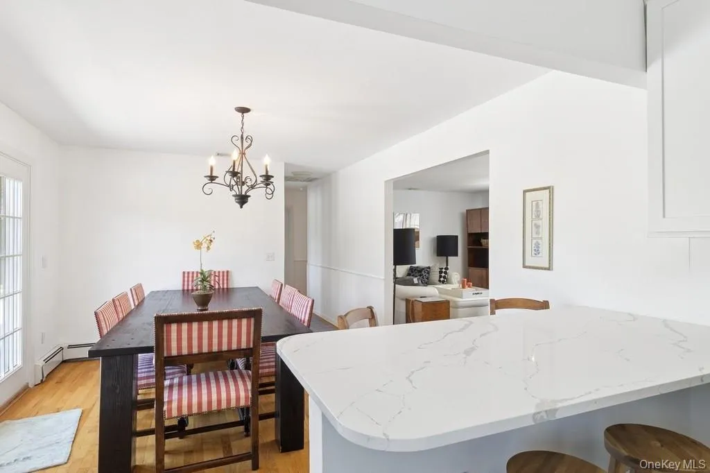 Dining area with light wood-type flooring and a chandelier Dining area with light wood-type flooring and a chandelier