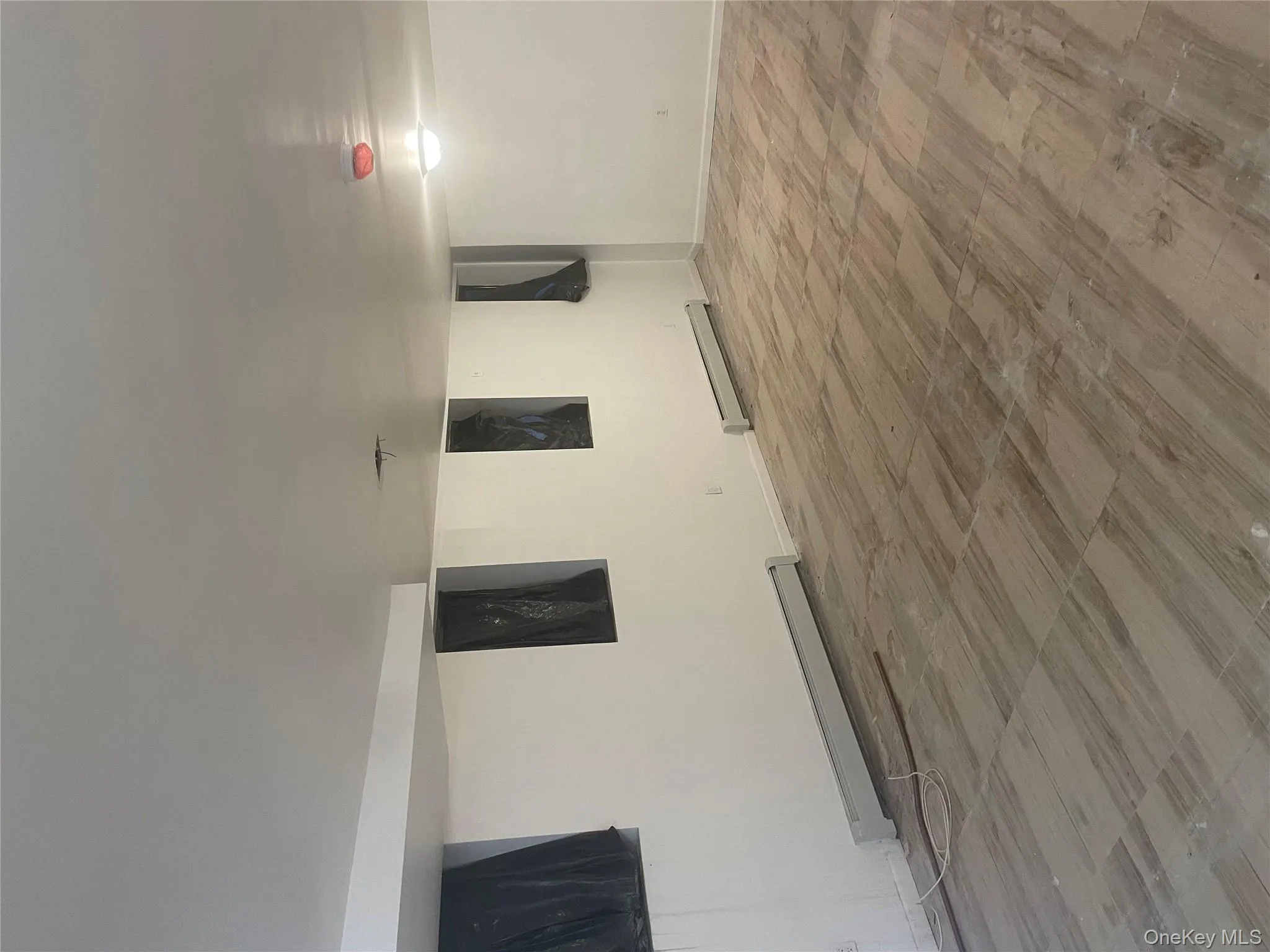 Finished below grade area with a baseboard heating unit, wood finished floors, and baseboards Finished below grade area with a baseboard heating unit, wood finished floors, and baseboards