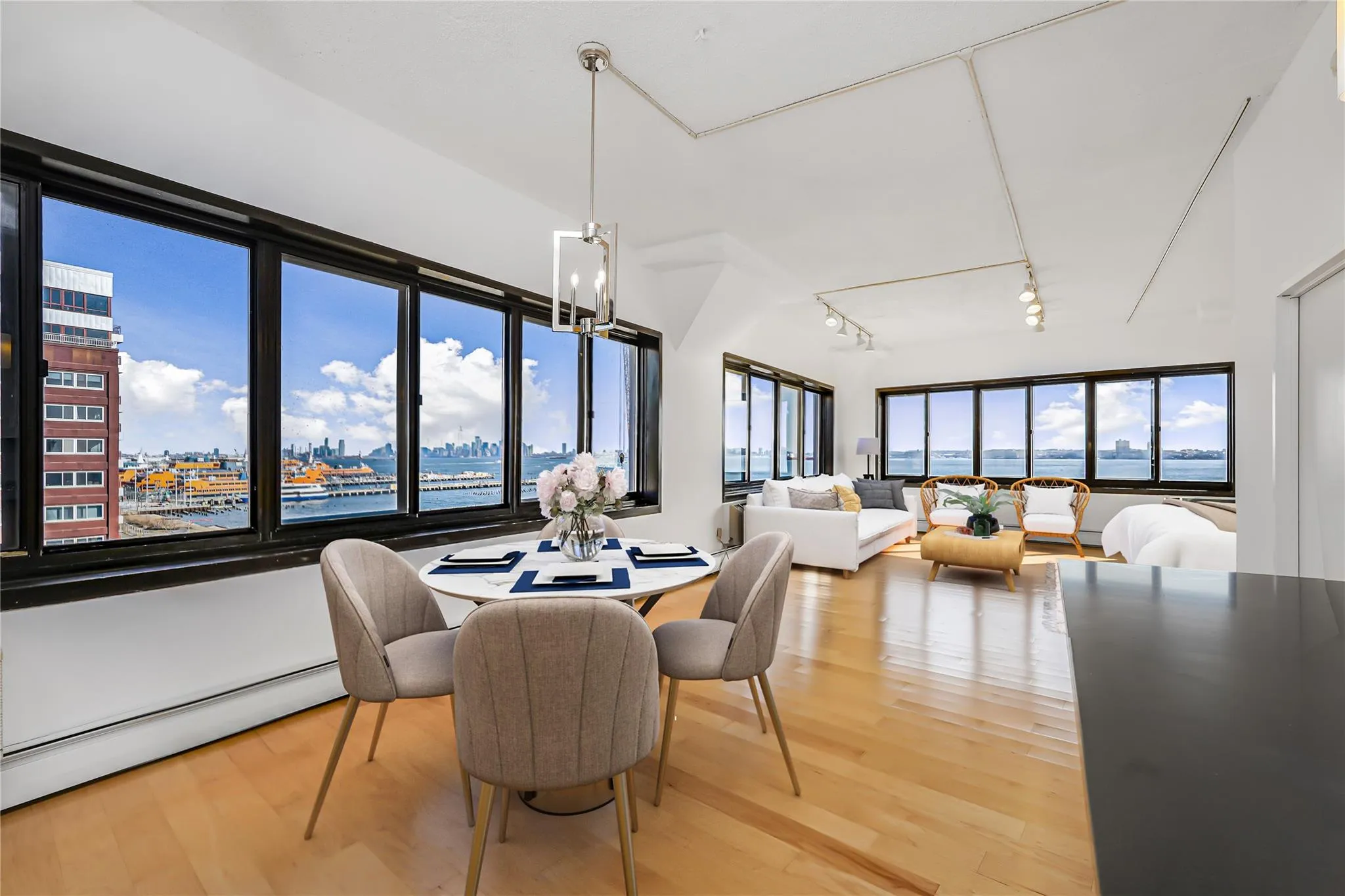 Dining space featuring baseboard heating, light wood finished floors, a chandelier, track lighting, and a view of city Dining space featuring baseboard heating, light wood finished floors, a chandelier, track lighting, and a view of city