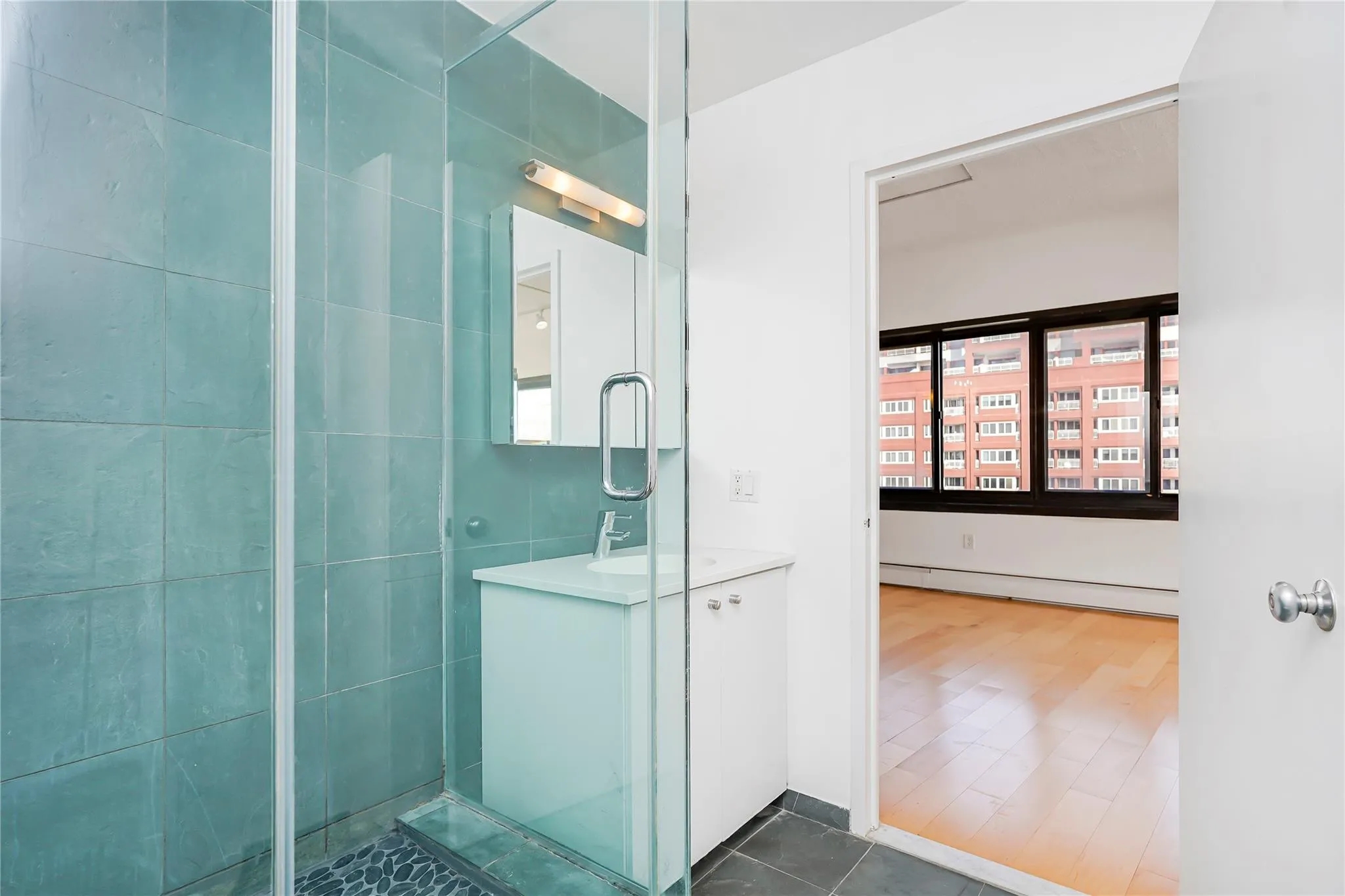 Full bath featuring baseboard heating, vanity, and a stall shower Full bath featuring baseboard heating, vanity, and a stall shower