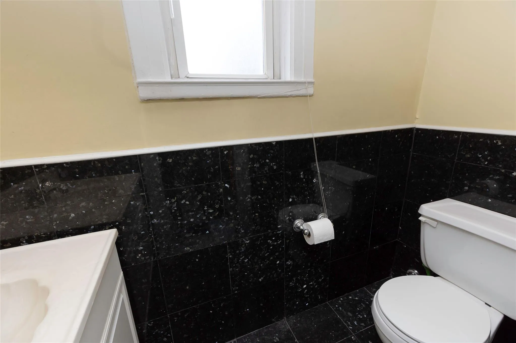 Bathroom featuring toilet, tile walls, wainscoting, and vanity Bathroom featuring toilet, tile walls, wainscoting, and vanity