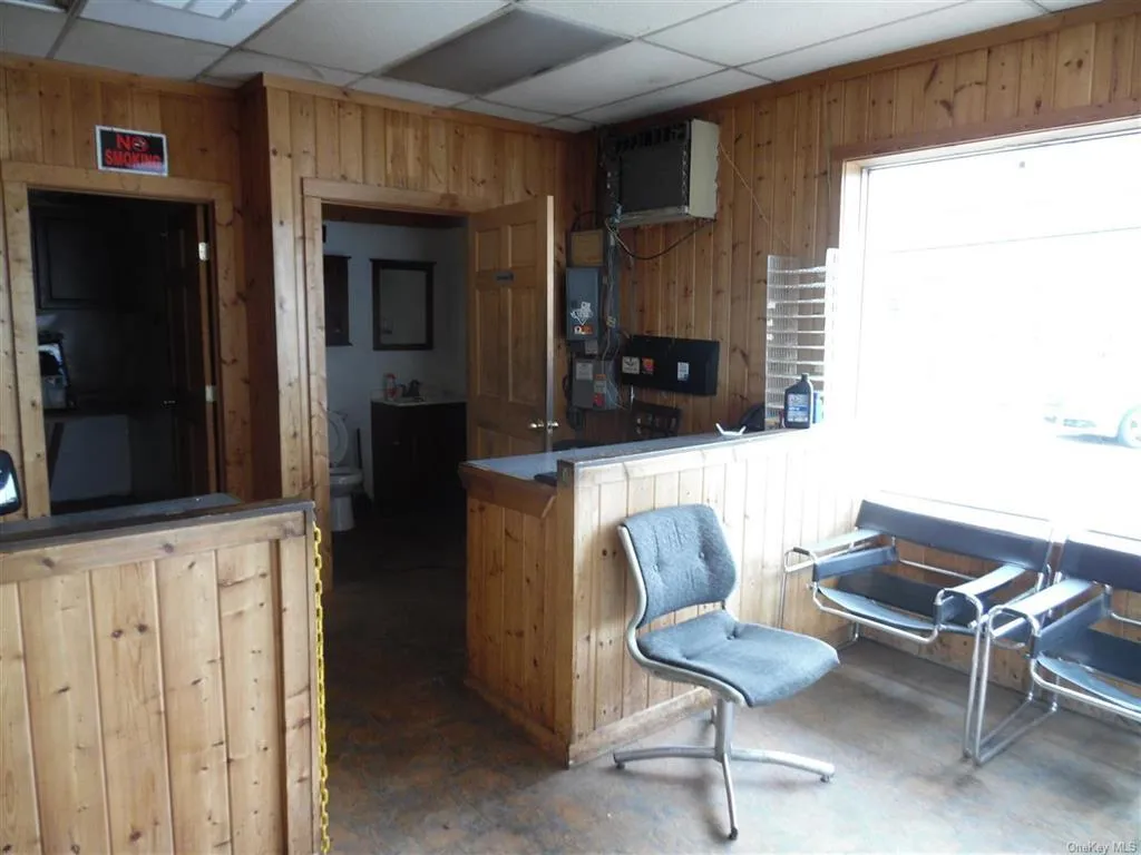 Kitchen featuring wooden walls and a paneled ceiling Kitchen featuring wooden walls and a paneled ceiling