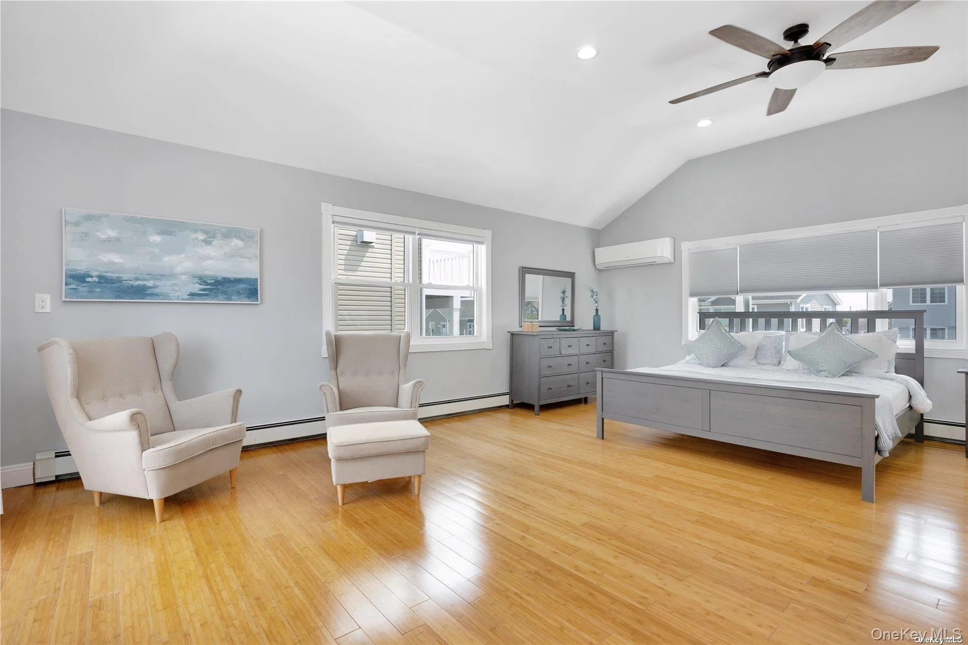 Bedroom featuring a baseboard radiator, an AC wall unit, lofted ceiling, wood finished floors, and recessed lighting Bedroom featuring a baseboard radiator, an AC wall unit, lofted ceiling, wood finished floors, and recessed lighting