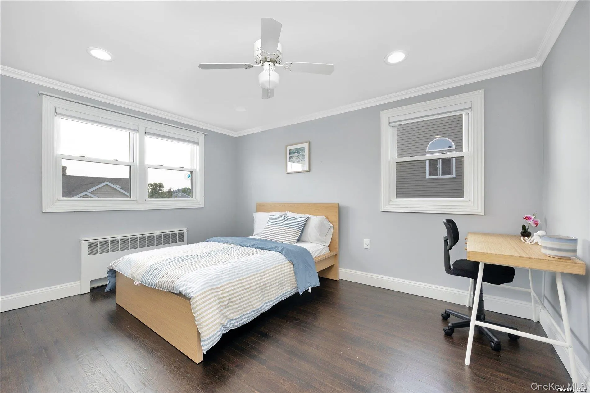 Bedroom featuring radiator, baseboards, recessed lighting, dark wood-type flooring, and crown molding Bedroom featuring radiator, baseboards, recessed lighting, dark wood-type flooring, and crown molding