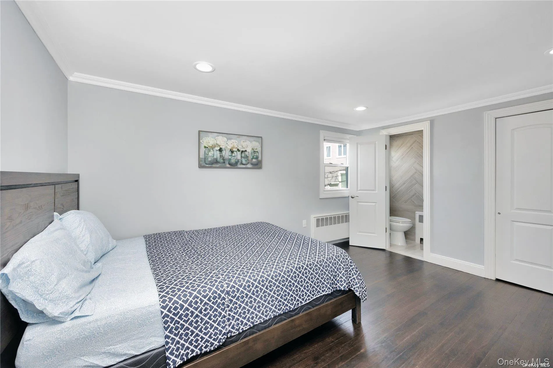 Bedroom featuring radiator heating unit, wood finished floors, recessed lighting, crown molding, and baseboards Bedroom featuring radiator heating unit, wood finished floors, recessed lighting, crown molding, and baseboards