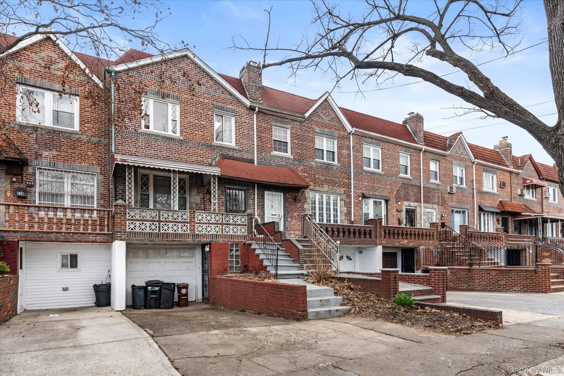 Townhome / multi-family property with brick siding, a garage, a chimney, concrete driveway, and stairway Townhome / multi-family property with brick siding, a garage, a chimney, concrete driveway, and stairway