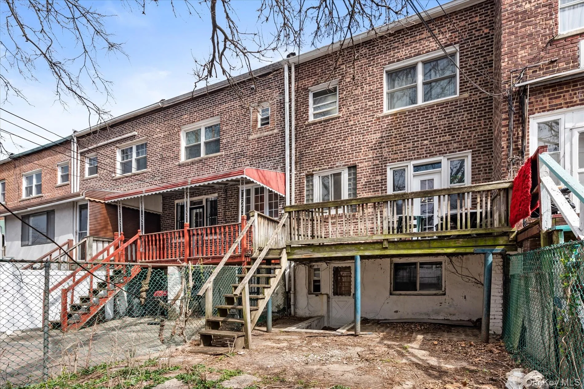 Rear view of property featuring stairs, brick siding, and a deck Rear view of property featuring stairs, brick siding, and a deck