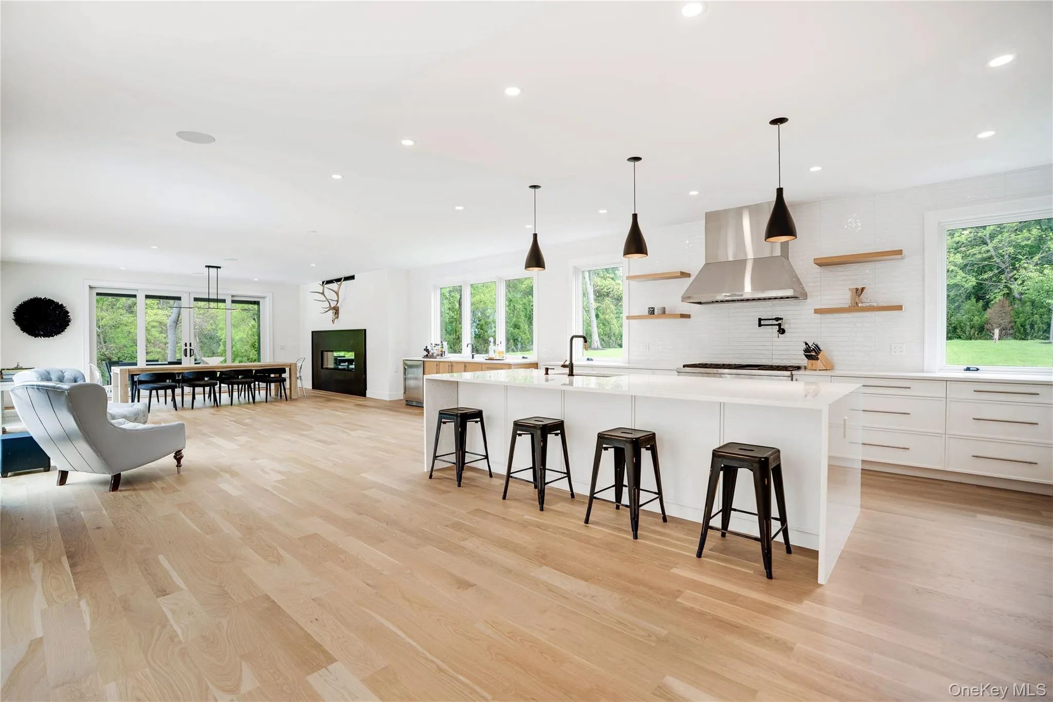 Kitchen with wall chimney exhaust hood, open shelves, light countertops, healthy amount of natural light, and recessed lighting Kitchen with wall chimney exhaust hood, open shelves, light countertops, healthy amount of natural light, and recessed lighting