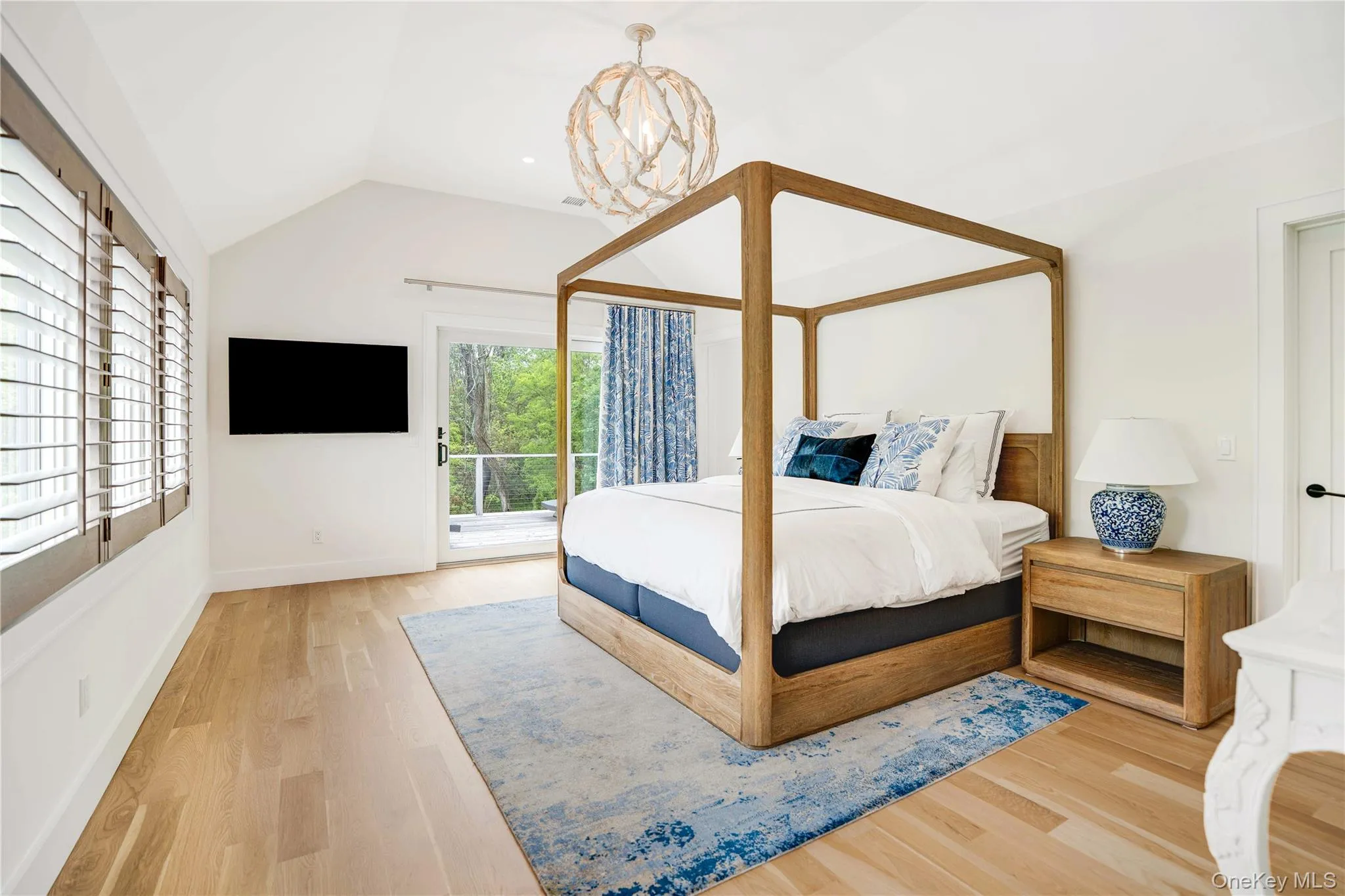 Bedroom with access to exterior, wood finished floors, lofted ceiling, and baseboards Bedroom with access to exterior, wood finished floors, lofted ceiling, and baseboards