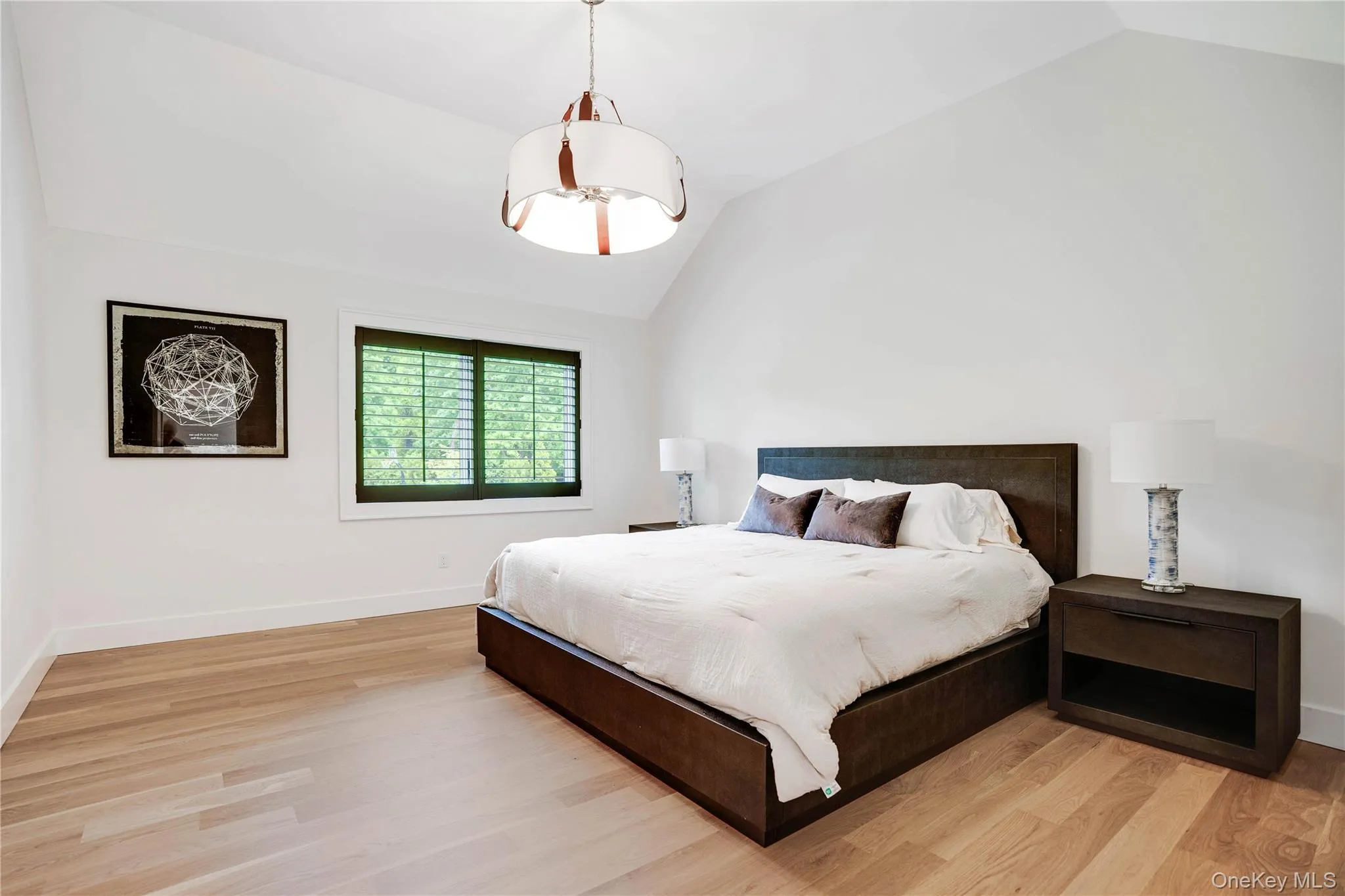 Bedroom with vaulted ceiling, light wood finished floors, and baseboards Bedroom with vaulted ceiling, light wood finished floors, and baseboards