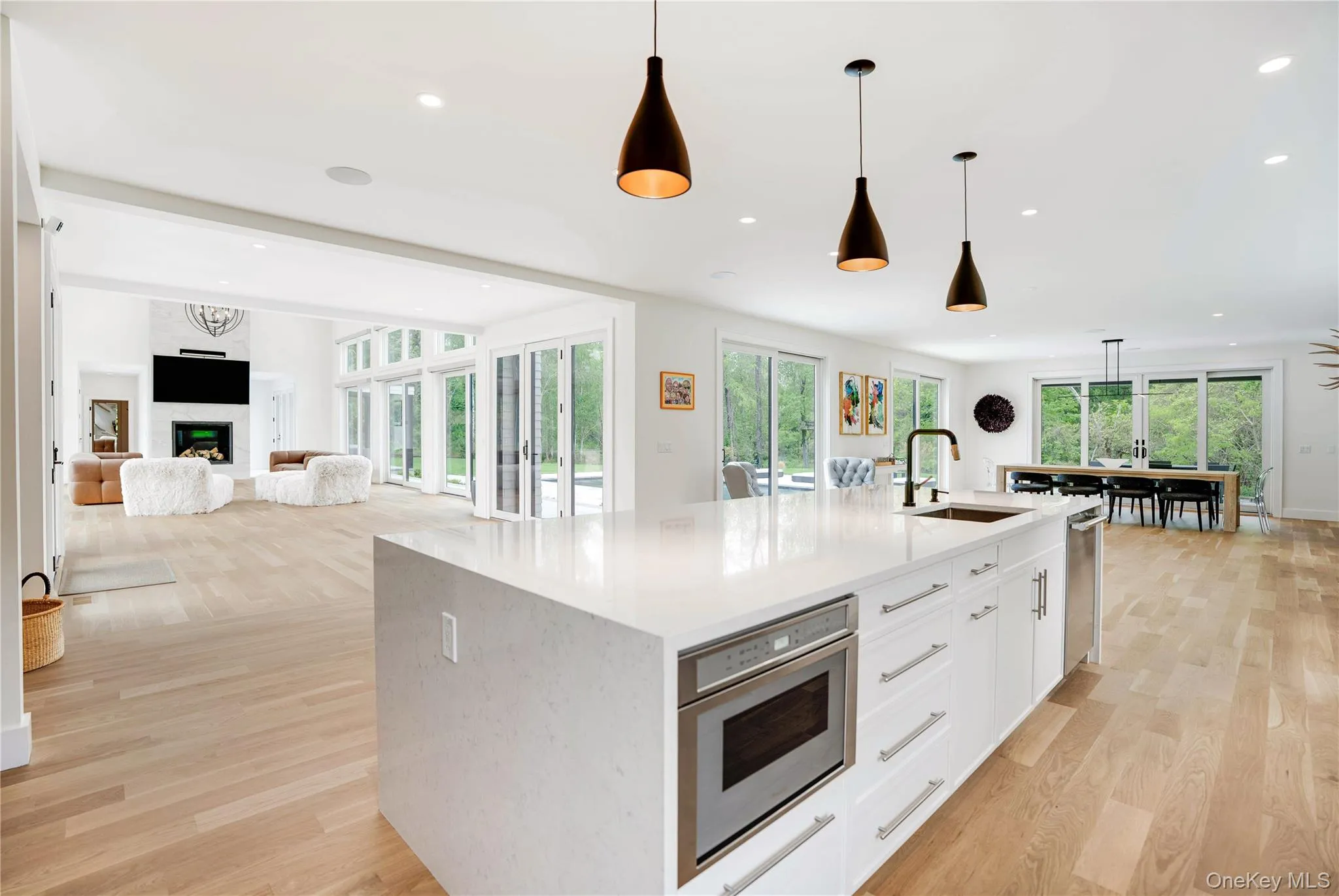 Kitchen featuring a sink, recessed lighting, an island with sink, white cabinets, and light wood-style floors Kitchen featuring a sink, recessed lighting, an island with sink, white cabinets, and light wood-style floors