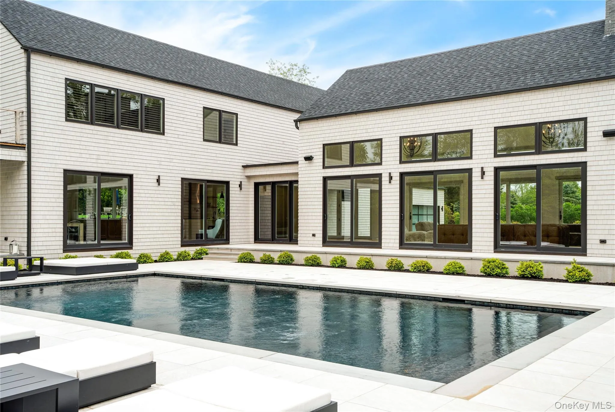 Back of property with an outdoor pool, a patio area, and a shingled roof Back of property with an outdoor pool, a patio area, and a shingled roof