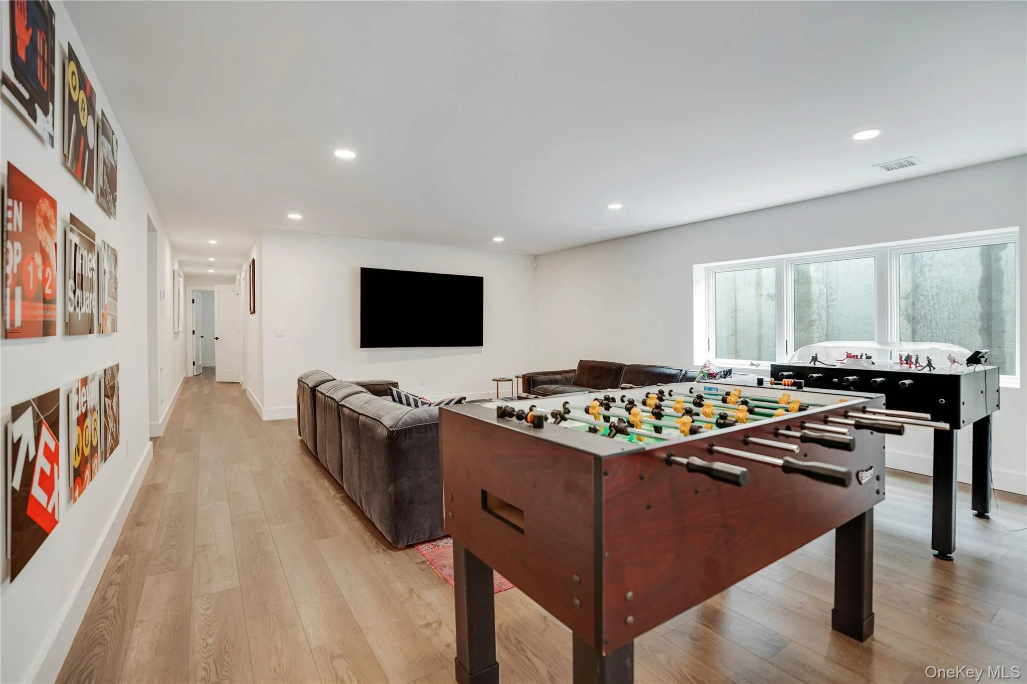 Recreation room featuring recessed lighting, light wood-style floors, and baseboards Recreation room featuring recessed lighting, light wood-style floors, and baseboards