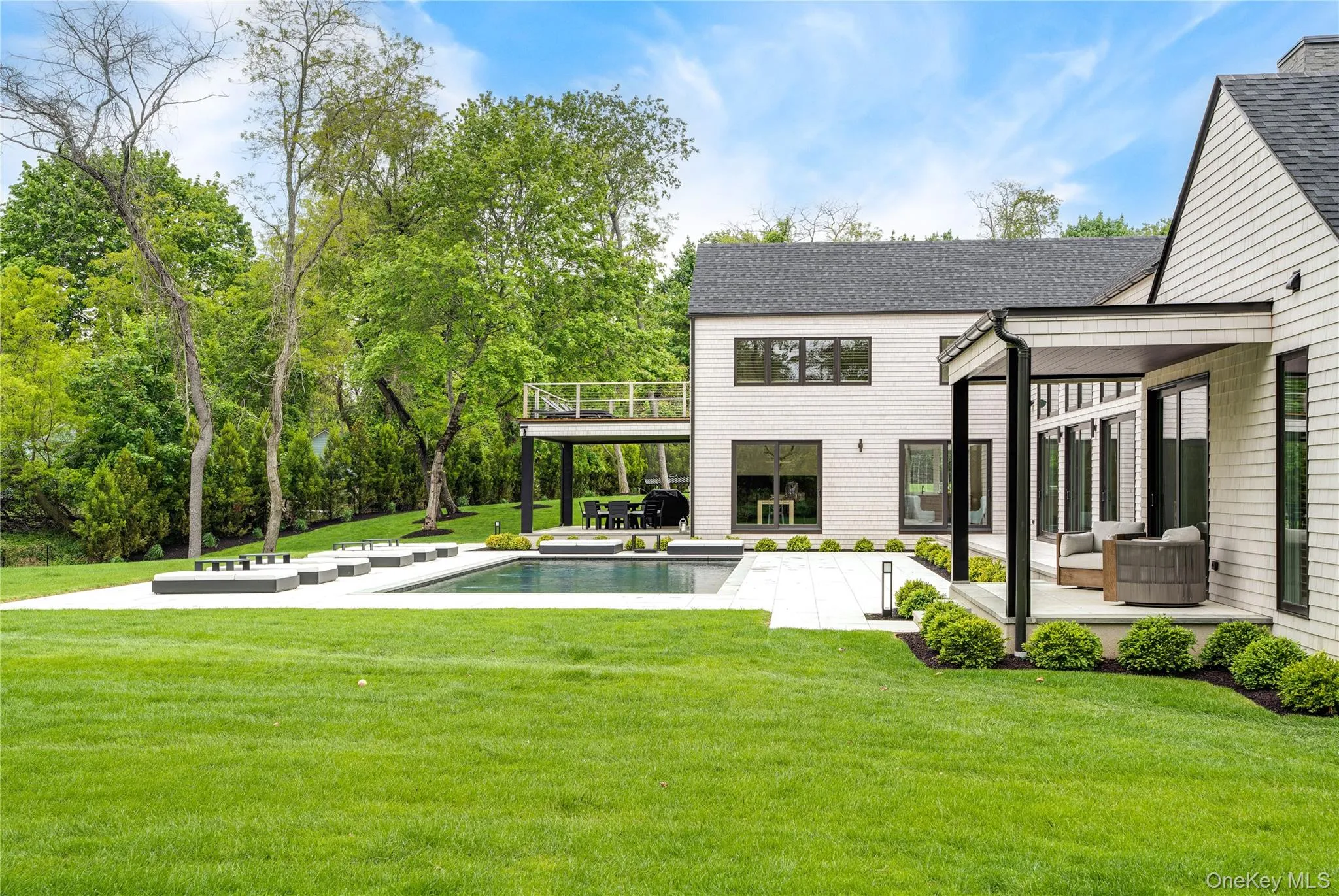 Back of property featuring an outdoor pool, a patio area, and a lawn Back of property featuring an outdoor pool, a patio area, and a lawn