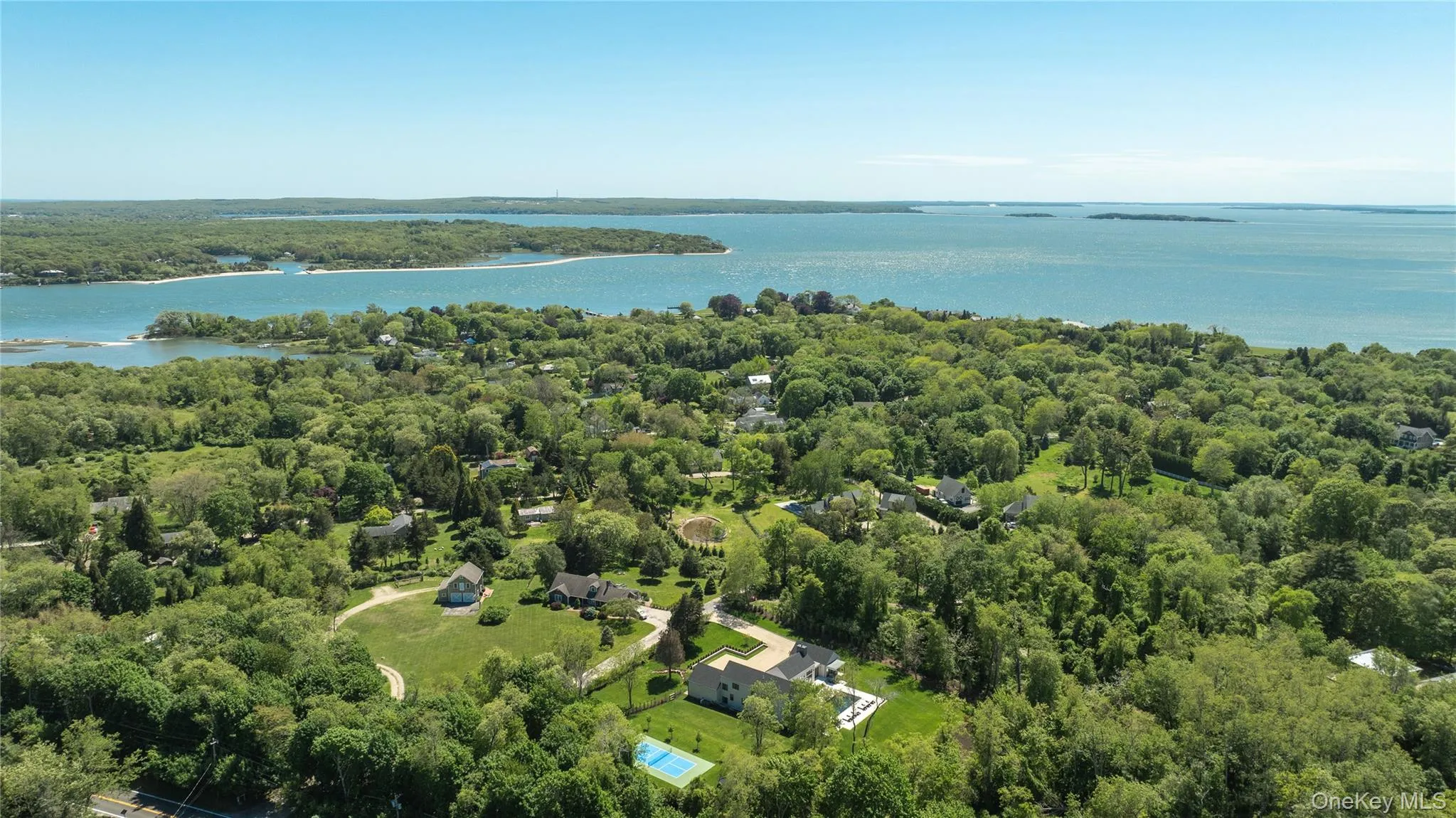 Aerial view of a nearby body of water and a heavily wooded area Aerial view of a nearby body of water and a heavily wooded area