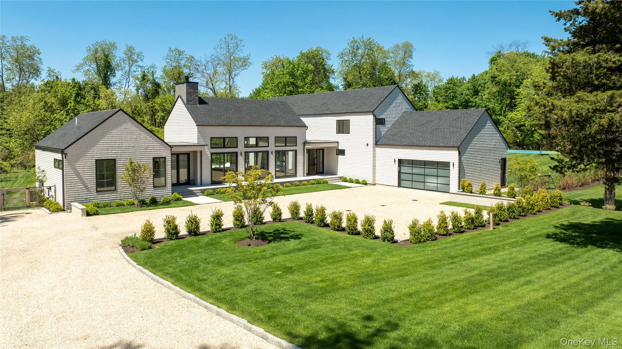 View of front of property with dirt driveway, a chimney, a garage, a front yard, and roof with shingles View of front of property with dirt driveway, a chimney, a garage, a front yard, and roof with shingles