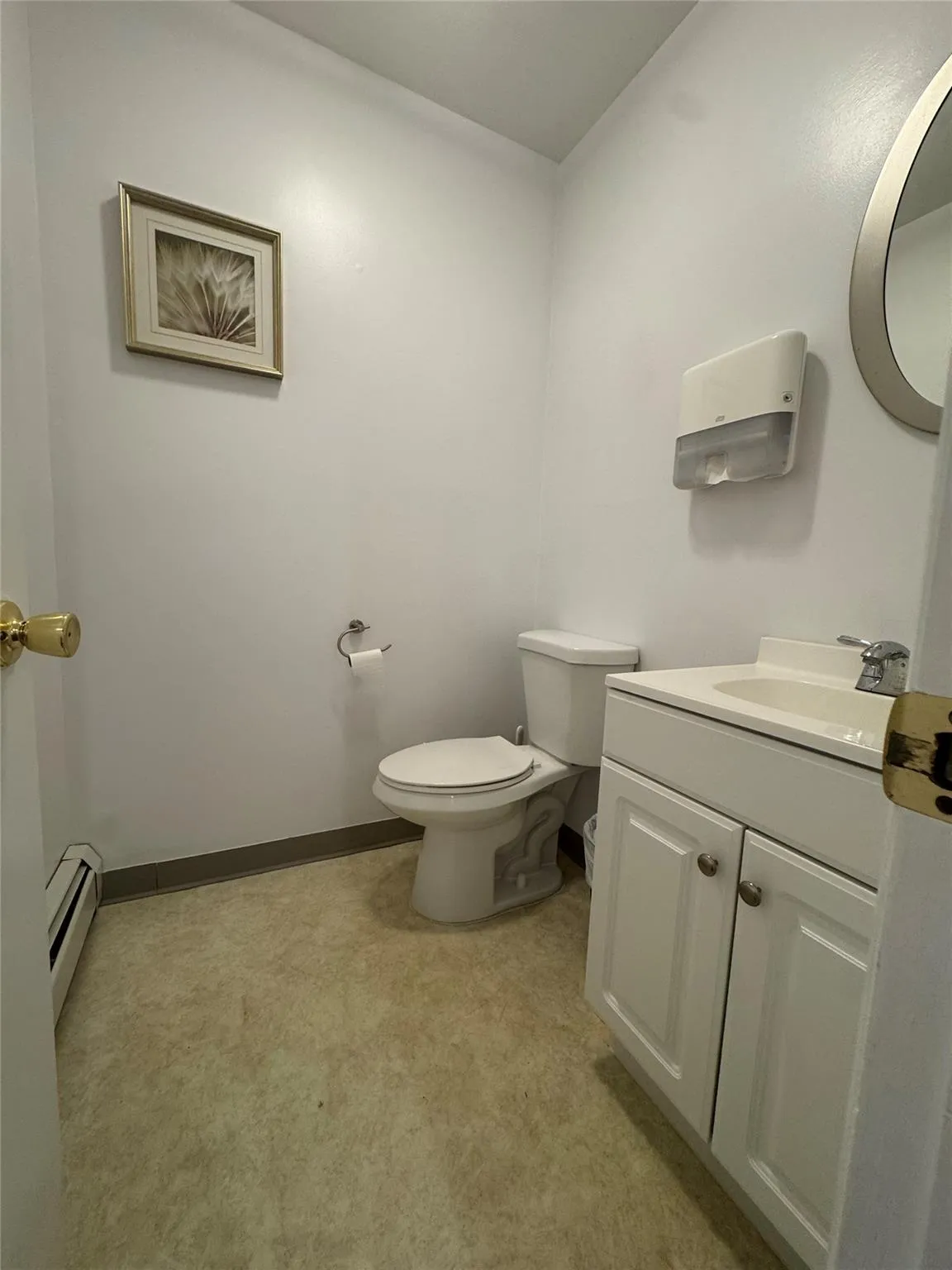 Half bathroom with baseboard heating, toilet, and vanity Half bathroom with baseboard heating, toilet, and vanity