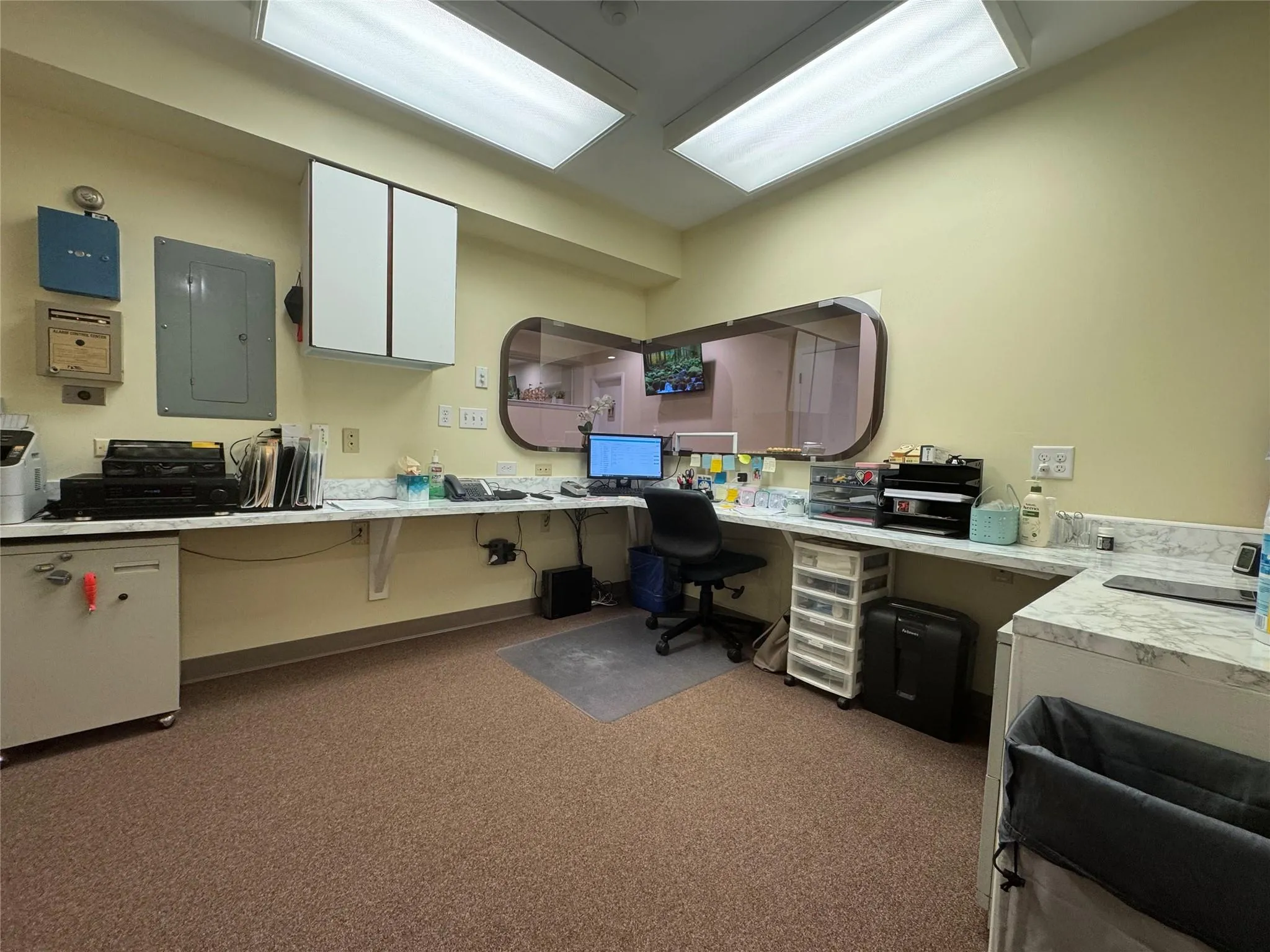 Carpeted office with built in desk and electric panel Carpeted office with built in desk and electric panel