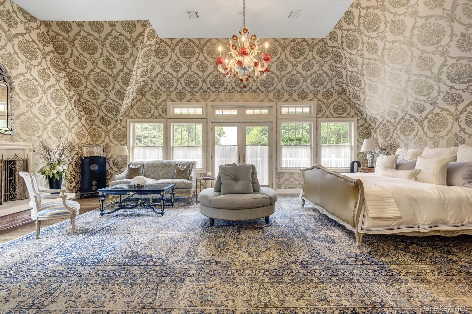 Bedroom with wallpapered walls, multiple windows, a chandelier, access to outside, and a towering ceiling Bedroom with wallpapered walls, multiple windows, a chandelier, access to outside, and a towering ceiling