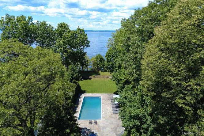 Bird's eye view of a nearby body of water and a pool area Bird's eye view of a nearby body of water and a pool area