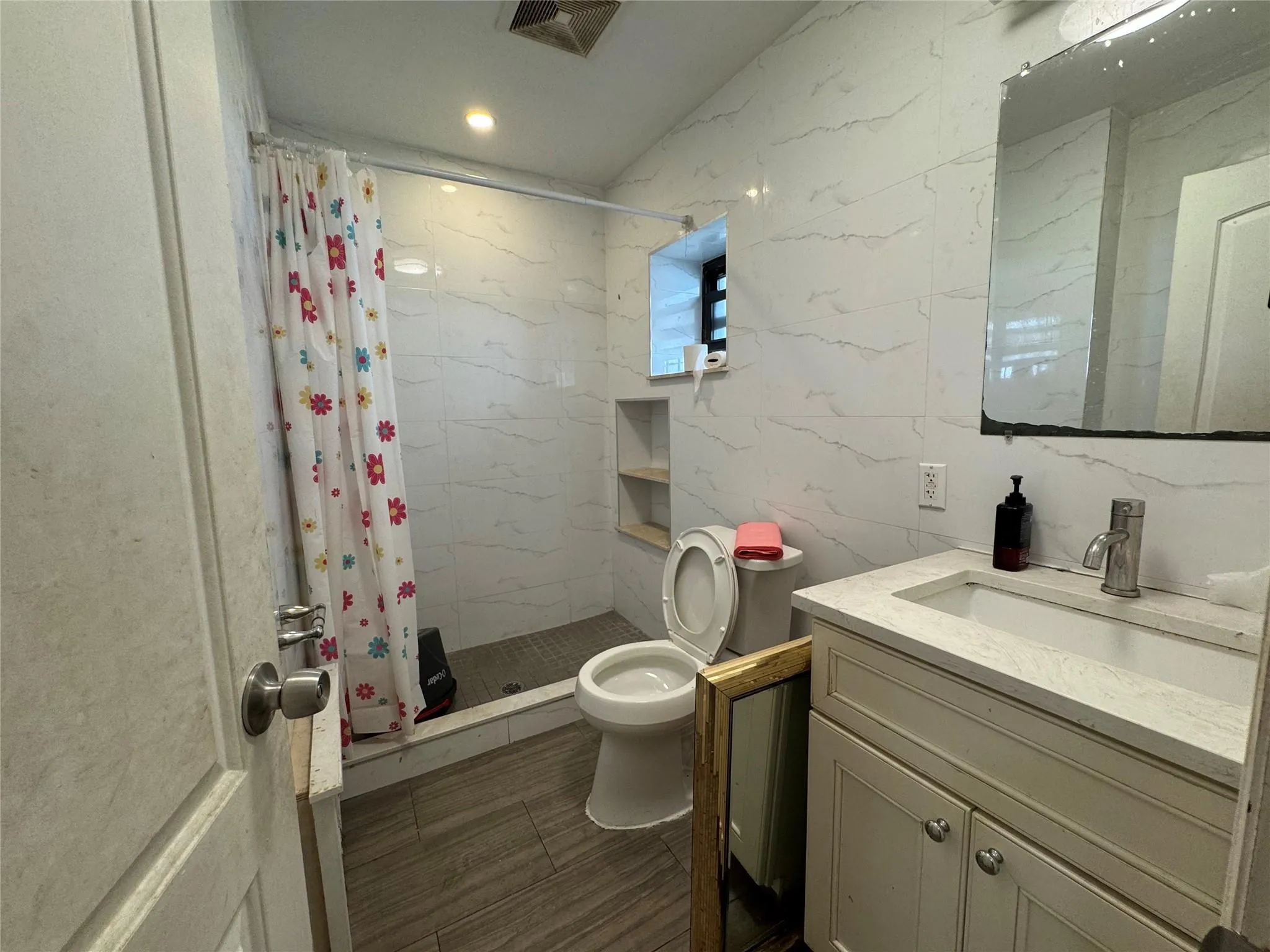 Full bath with a shower stall, toilet, vanity, and recessed lighting Full bath with a shower stall, toilet, vanity, and recessed lighting