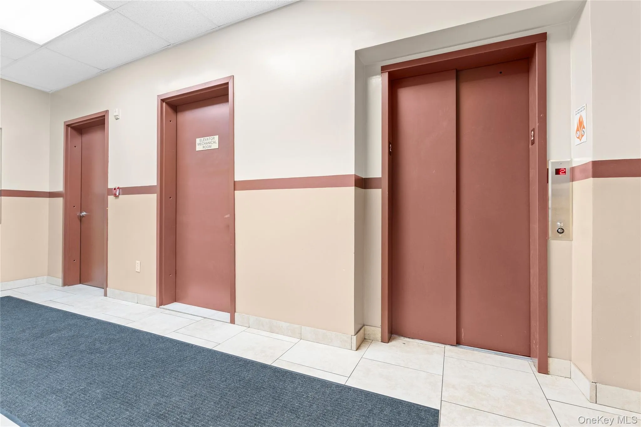 patterned floors, a drop ceiling, and baseboards patterned floors, a drop ceiling, and baseboards