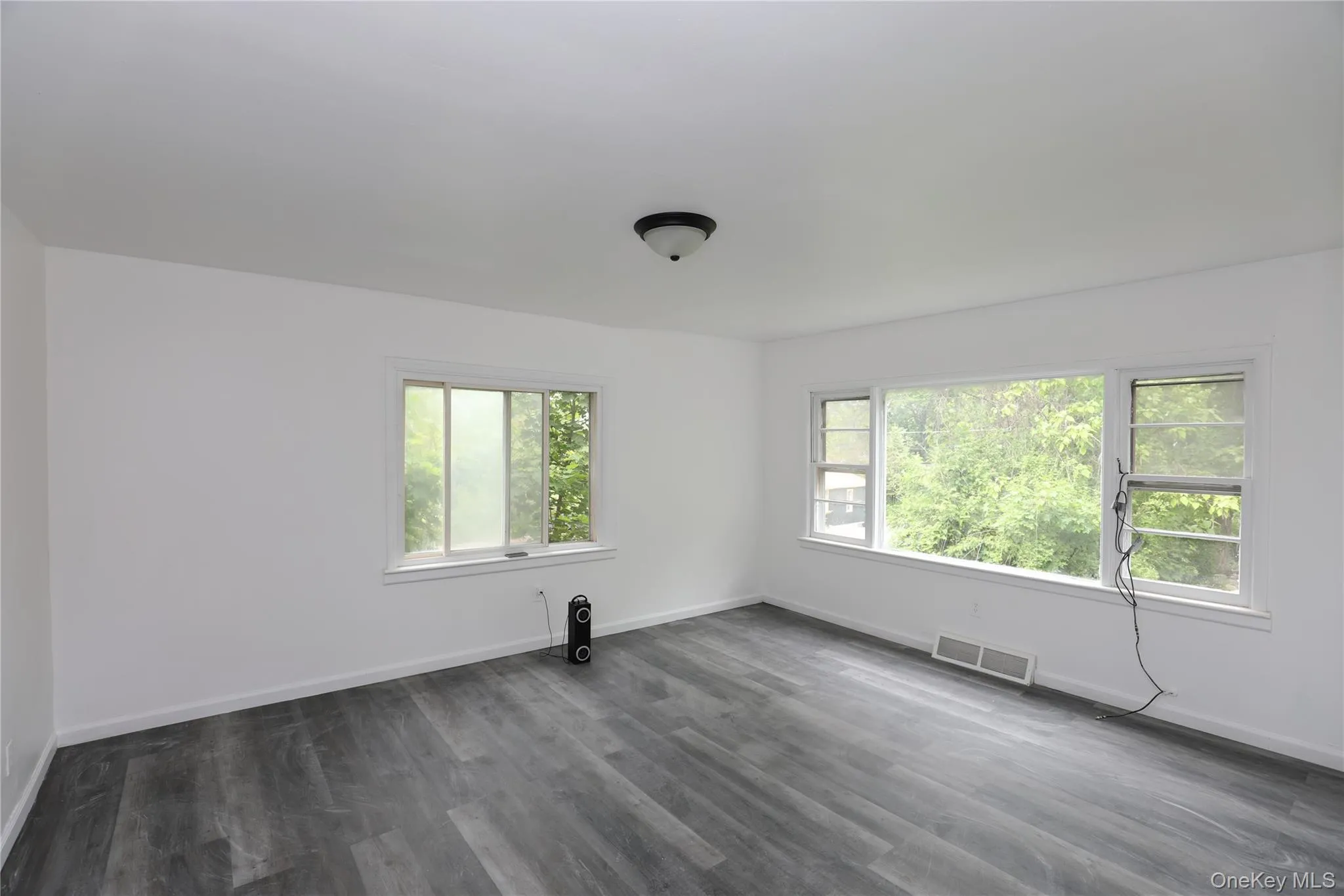 Empty room featuring dark wood-style flooring and baseboards Empty room featuring dark wood-style flooring and baseboards