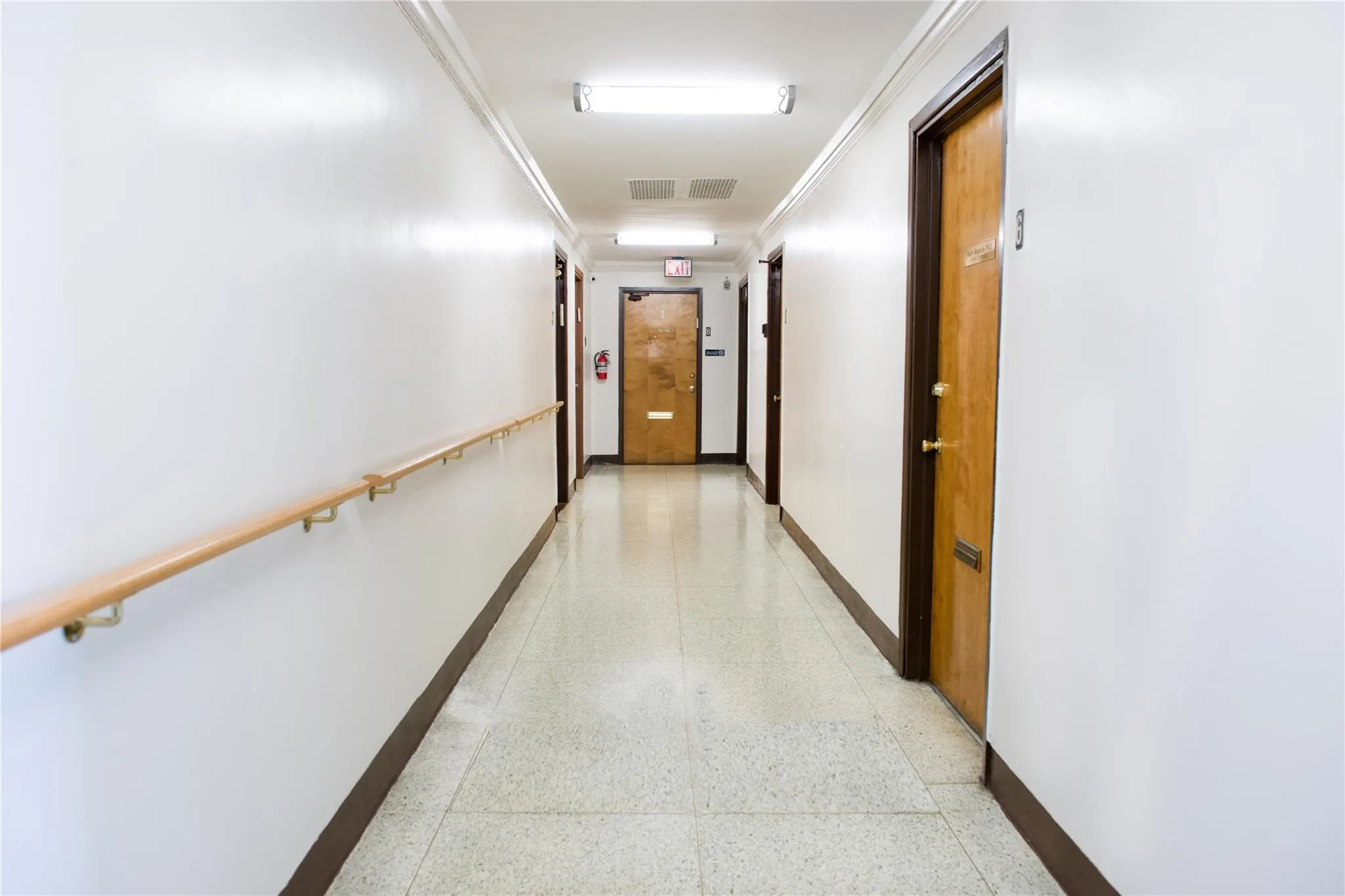 Corridor with dark aggregate flooring, baseboards, and crown molding Corridor with dark aggregate flooring, baseboards, and crown molding