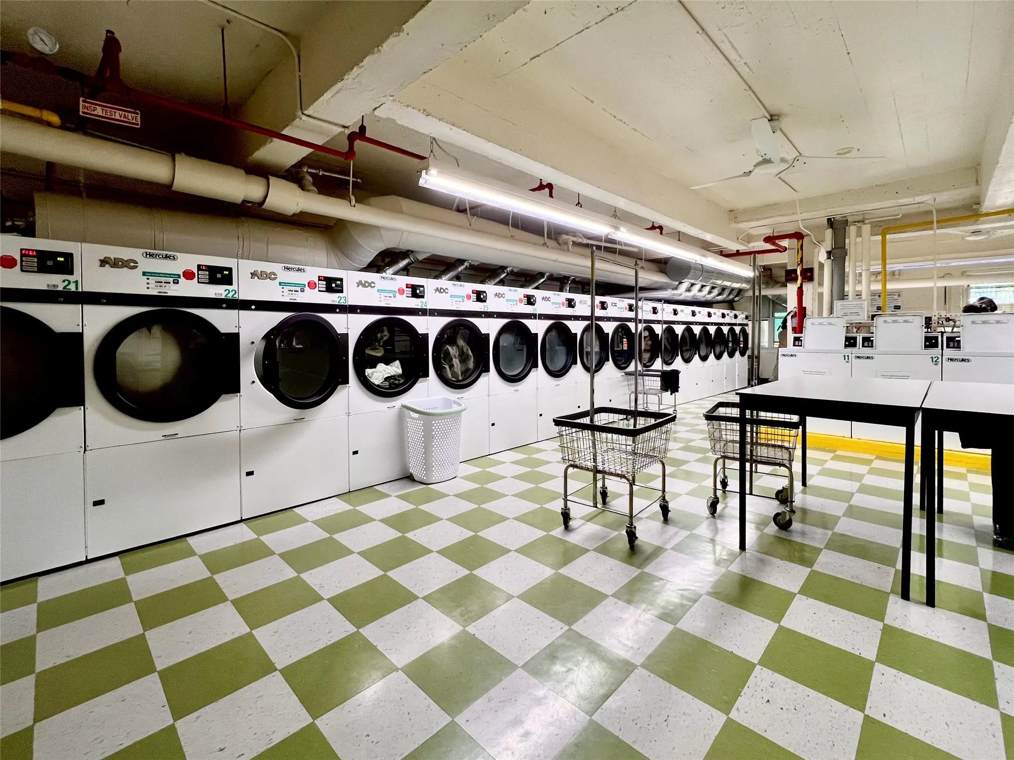 Community laundry room featuring washing machine and dryer and light flooring Community laundry room featuring washing machine and dryer and light flooring