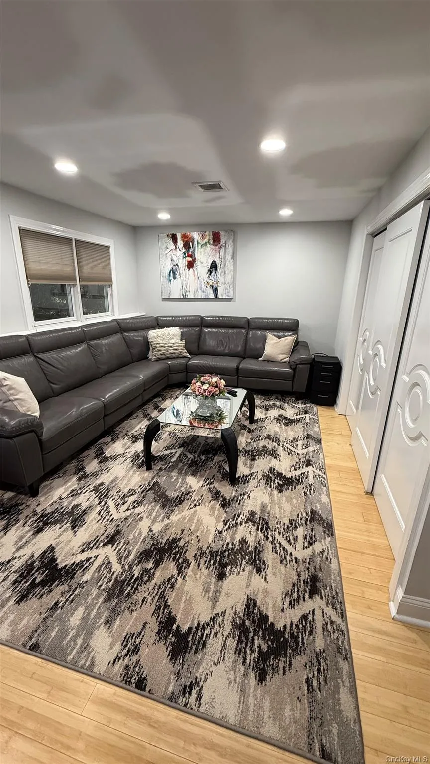 Living room featuring light wood-style flooring and recessed lighting Living room featuring light wood-style flooring and recessed lighting