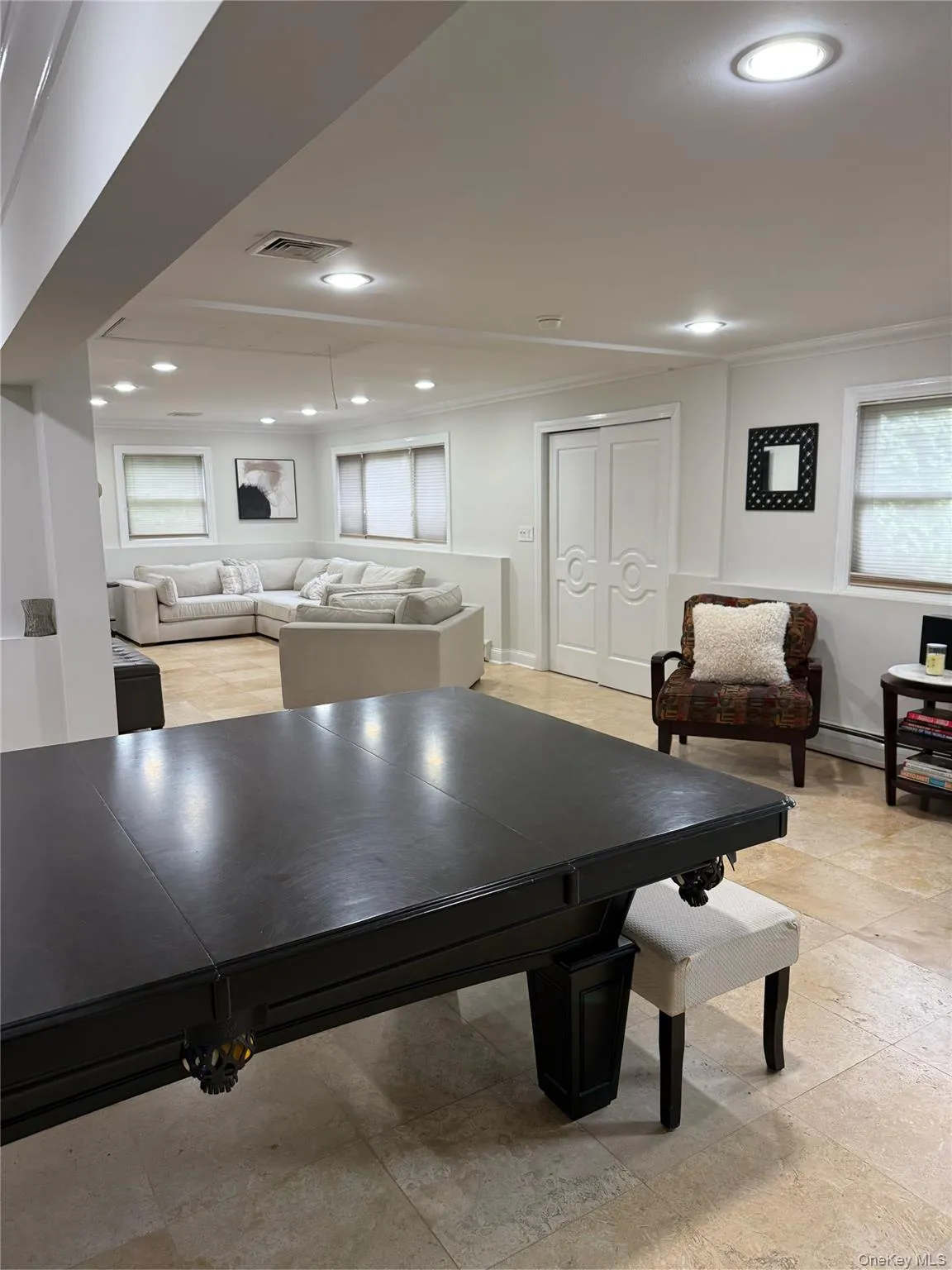Recreation room with recessed lighting, crown molding, baseboards, plenty of natural light, and light stone finish floors Recreation room with recessed lighting, crown molding, baseboards, plenty of natural light, and light stone finish floors