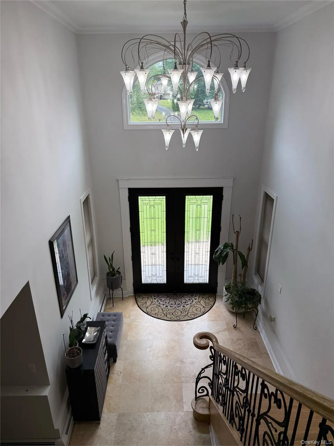 Entrance foyer featuring french doors, plenty of natural light, a chandelier, a towering ceiling, and crown molding Entrance foyer featuring french doors, plenty of natural light, a chandelier, a towering ceiling, and crown molding