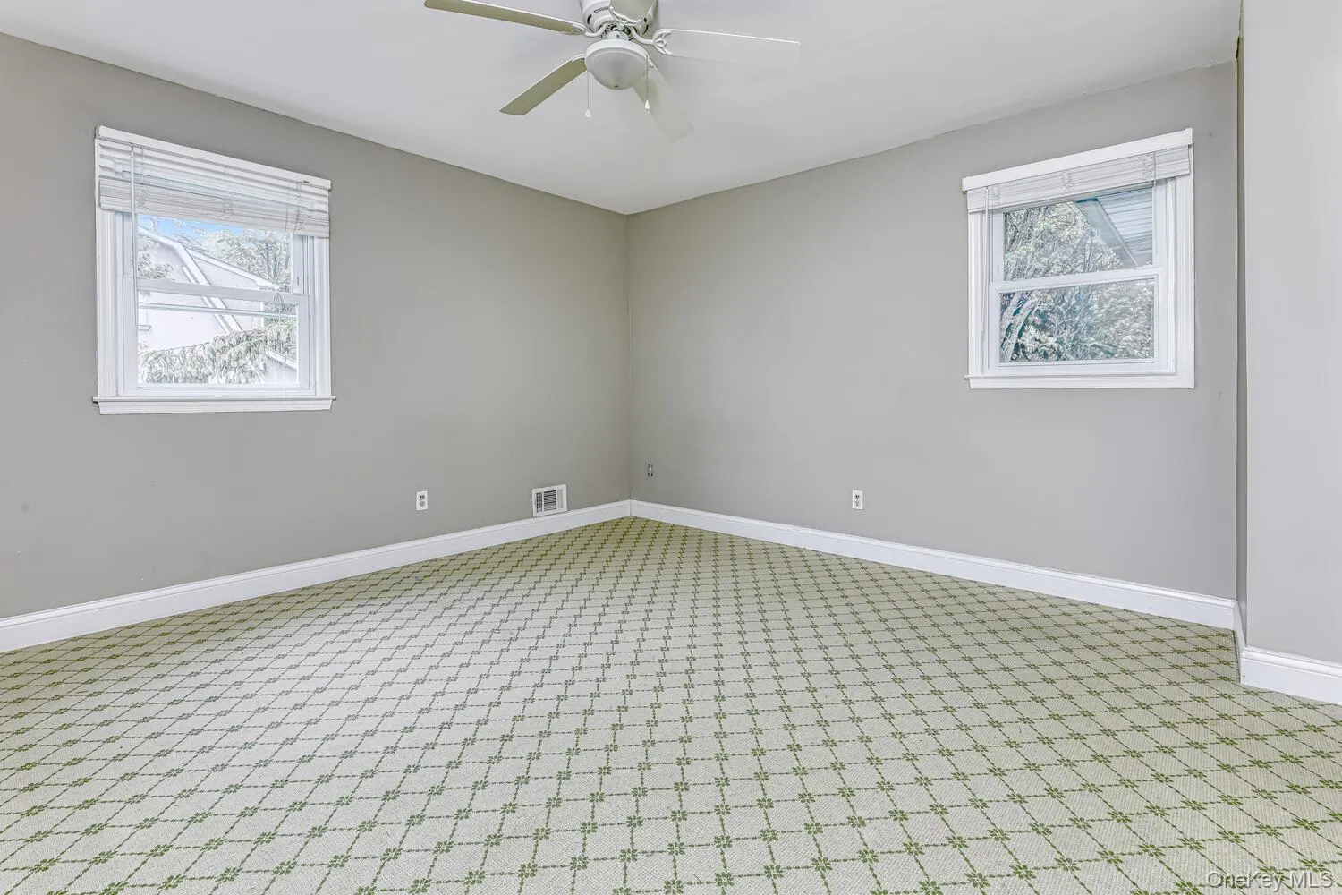 Spare room featuring healthy amount of natural light, carpet flooring, a ceiling fan, and baseboards Spare room featuring healthy amount of natural light, carpet flooring, a ceiling fan, and baseboards