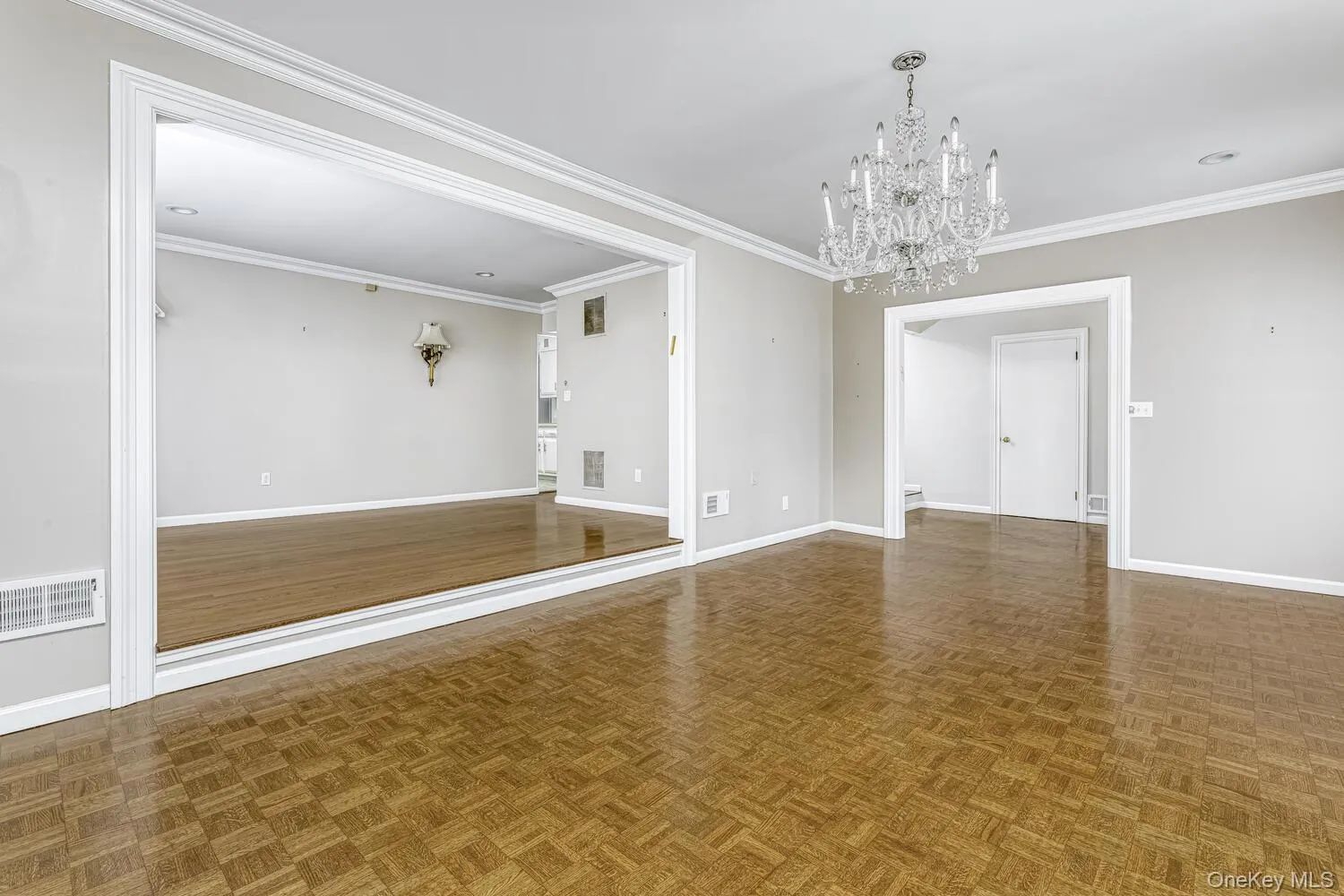Unfurnished room with a chandelier, baseboards, and crown molding Unfurnished room with a chandelier, baseboards, and crown molding
