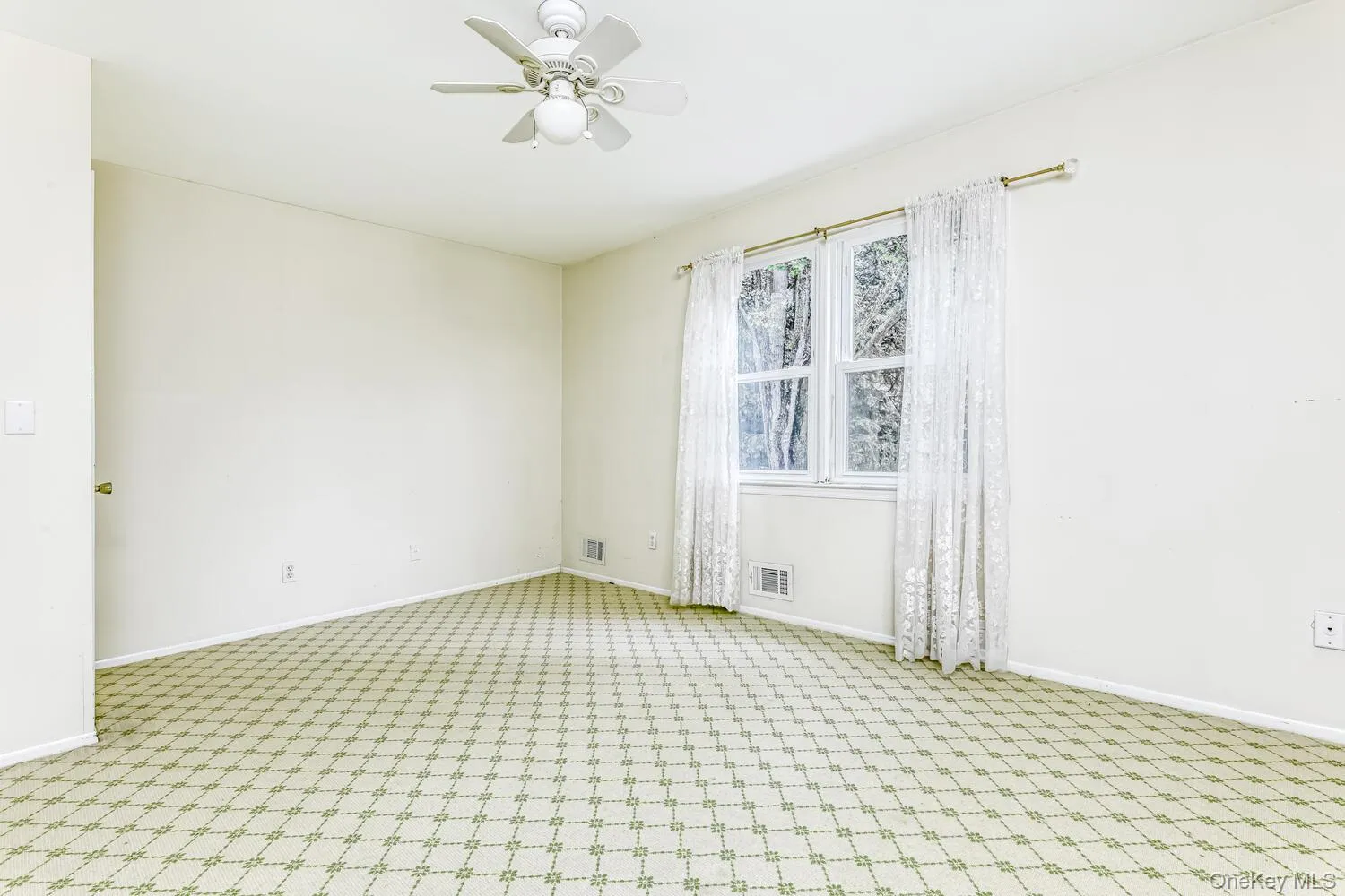 Spare room with light colored carpet, a ceiling fan, and baseboards Spare room with light colored carpet, a ceiling fan, and baseboards