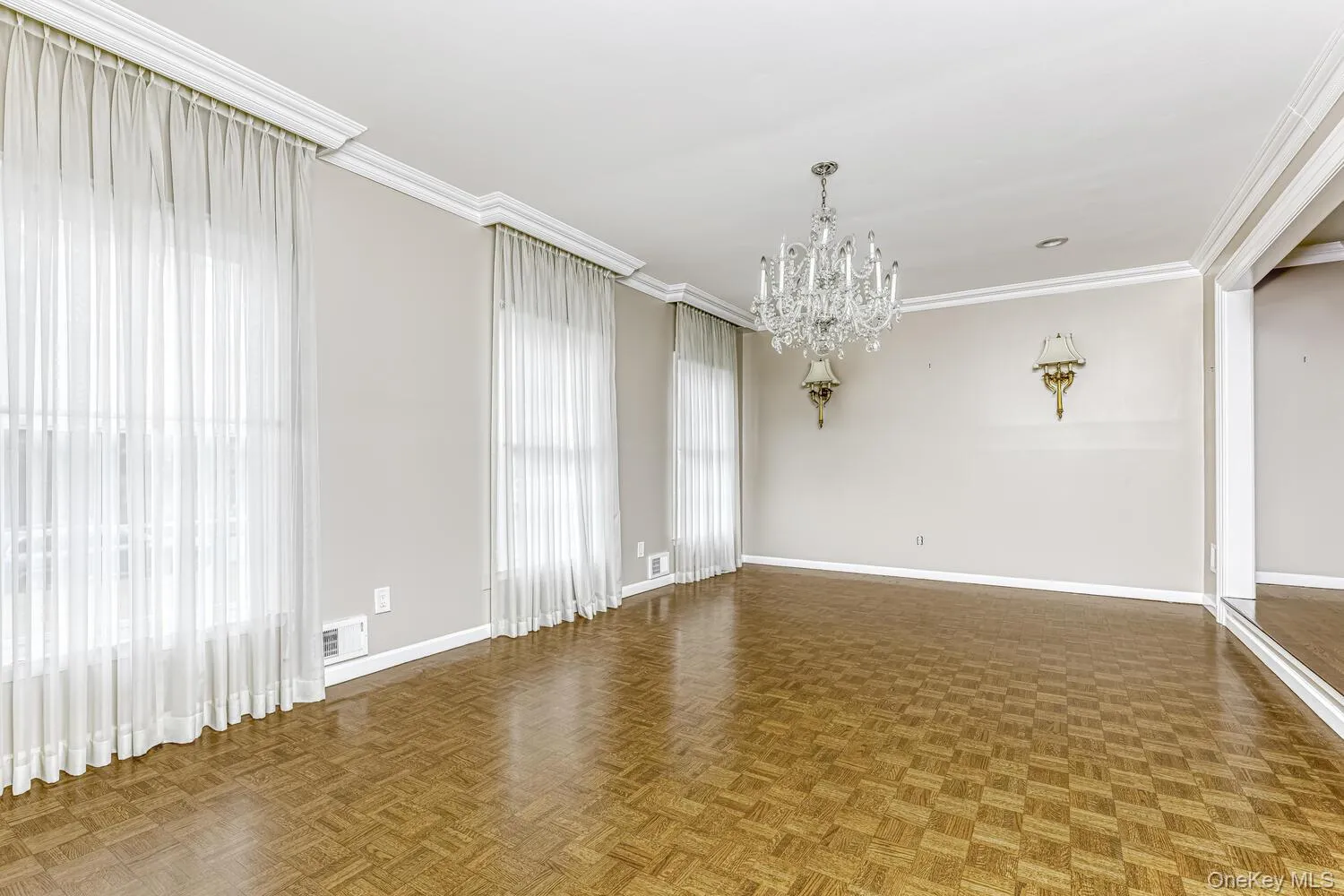 Spare room featuring baseboards, a chandelier, and ornamental molding Spare room featuring baseboards, a chandelier, and ornamental molding