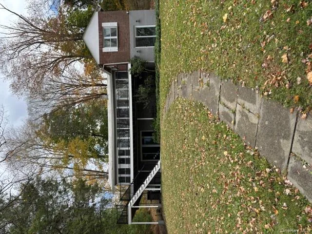 View of front of house with stairway, a front yard, and a wooden deck View of front of house with stairway, a front yard, and a wooden deck