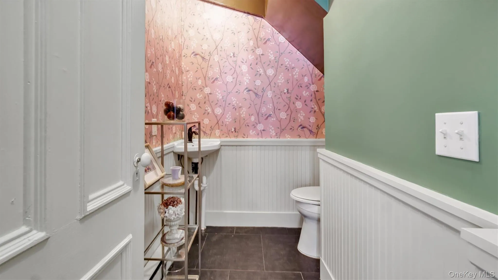 Bathroom with toilet, tile patterned floors, and wainscoting Bathroom with toilet, tile patterned floors, and wainscoting