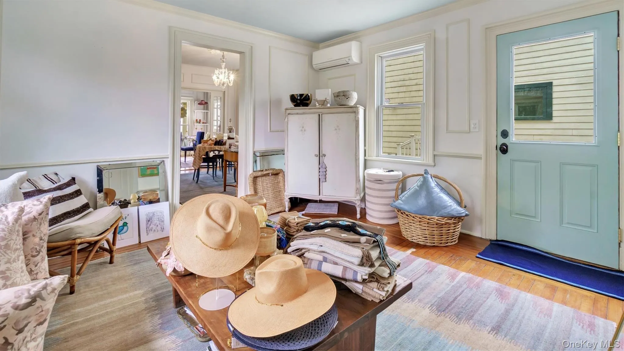 Living room featuring a wall mounted AC, wood finished floors, and crown molding Living room featuring a wall mounted AC, wood finished floors, and crown molding