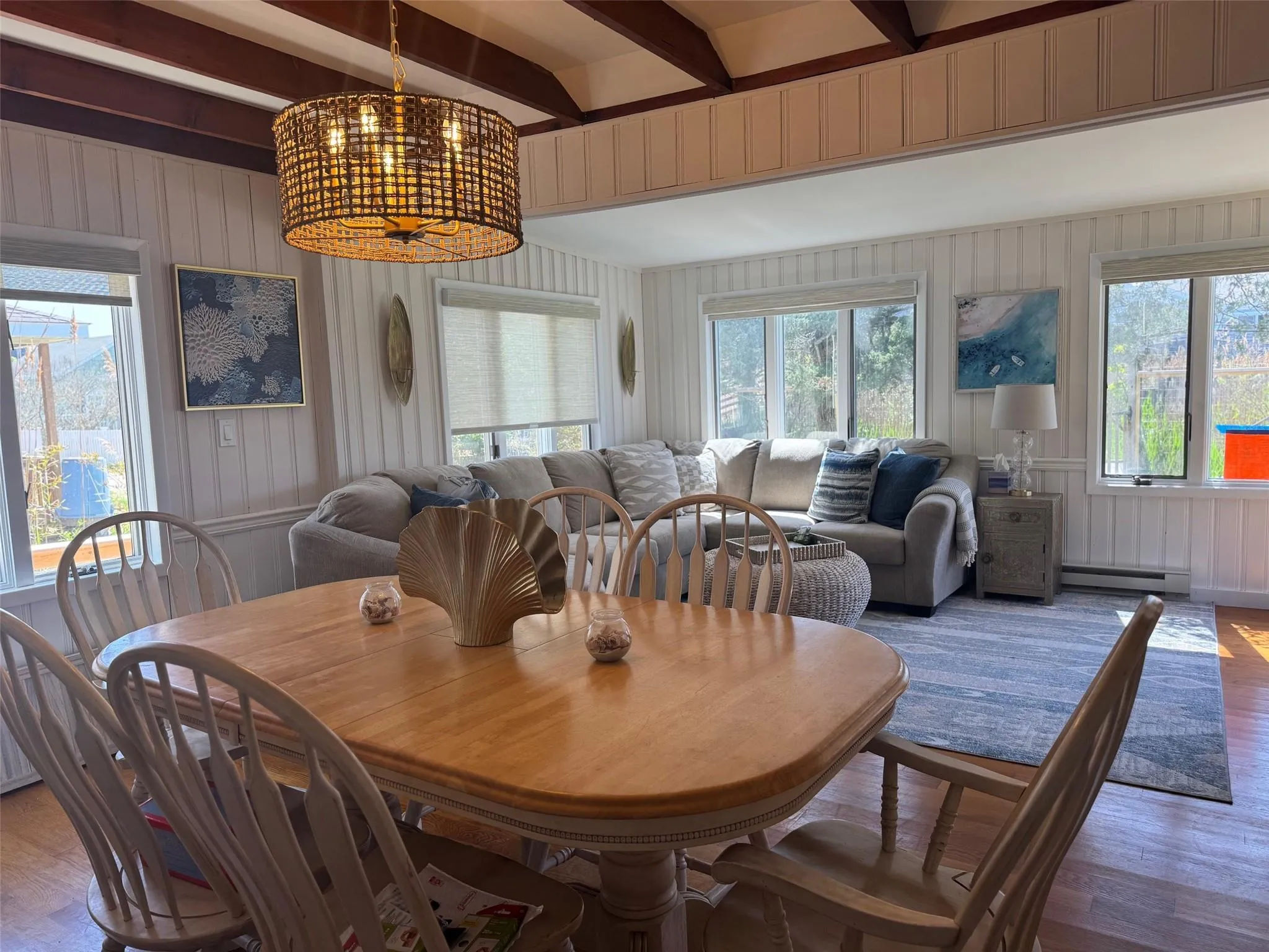 Dining space with light wood-type flooring, plenty of natural light, beam ceiling, and baseboard heating Dining space with light wood-type flooring, plenty of natural light, beam ceiling, and baseboard heating