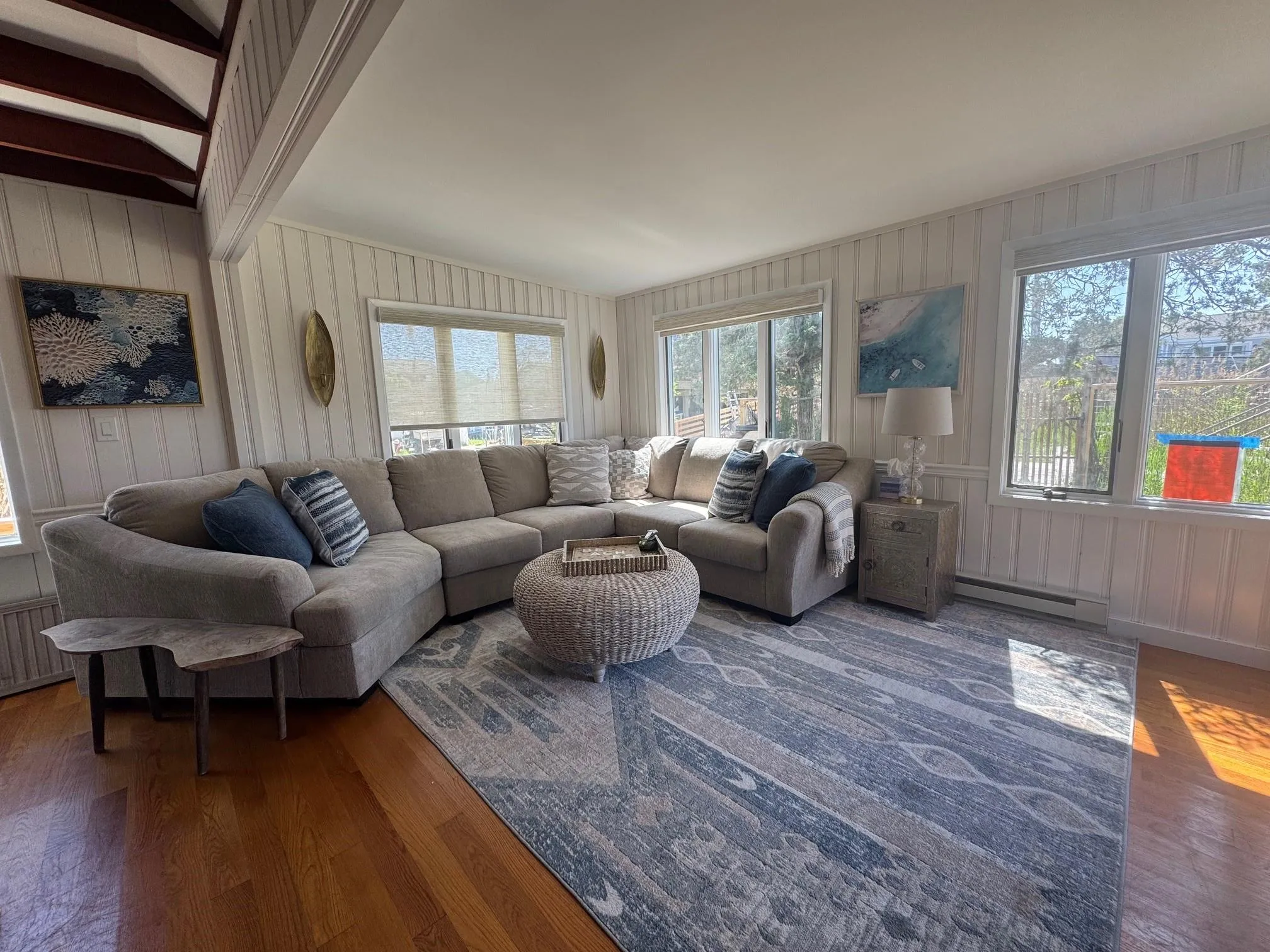 Living room with wood finished floors, plenty of natural light, and baseboard heating Living room with wood finished floors, plenty of natural light, and baseboard heating