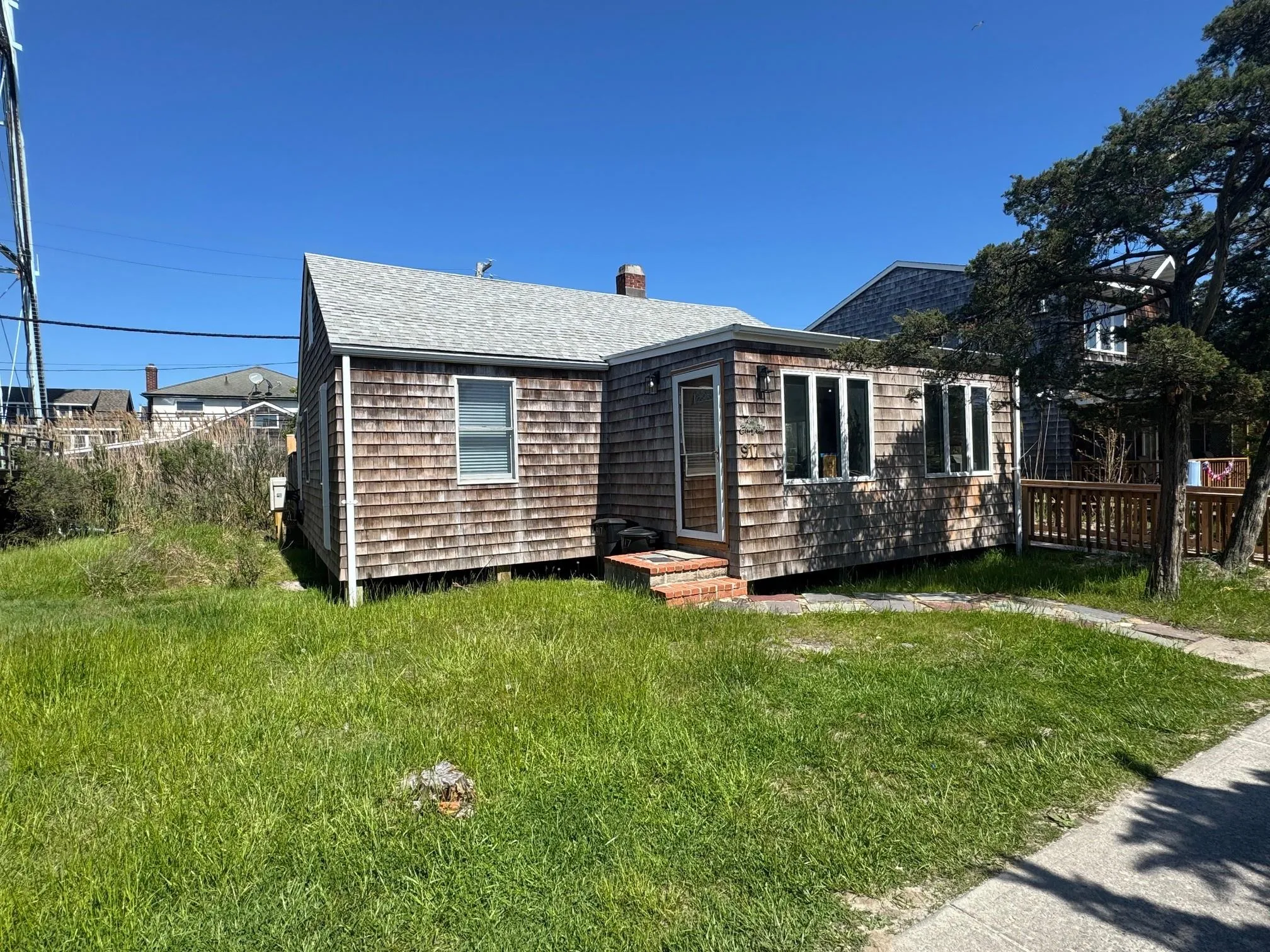 View of front of property featuring a chimney, roof with shingles, and a front yard View of front of property featuring a chimney, roof with shingles, and a front yard