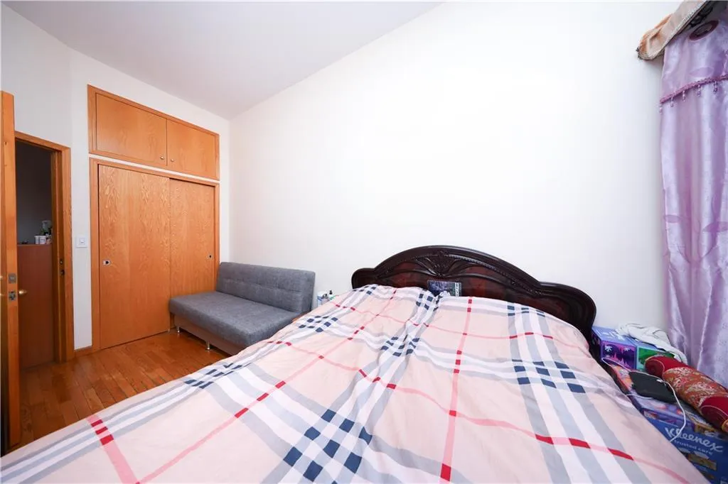 Bedroom featuring wood finished floors, lofted ceiling, and a closet Bedroom featuring wood finished floors, lofted ceiling, and a closet