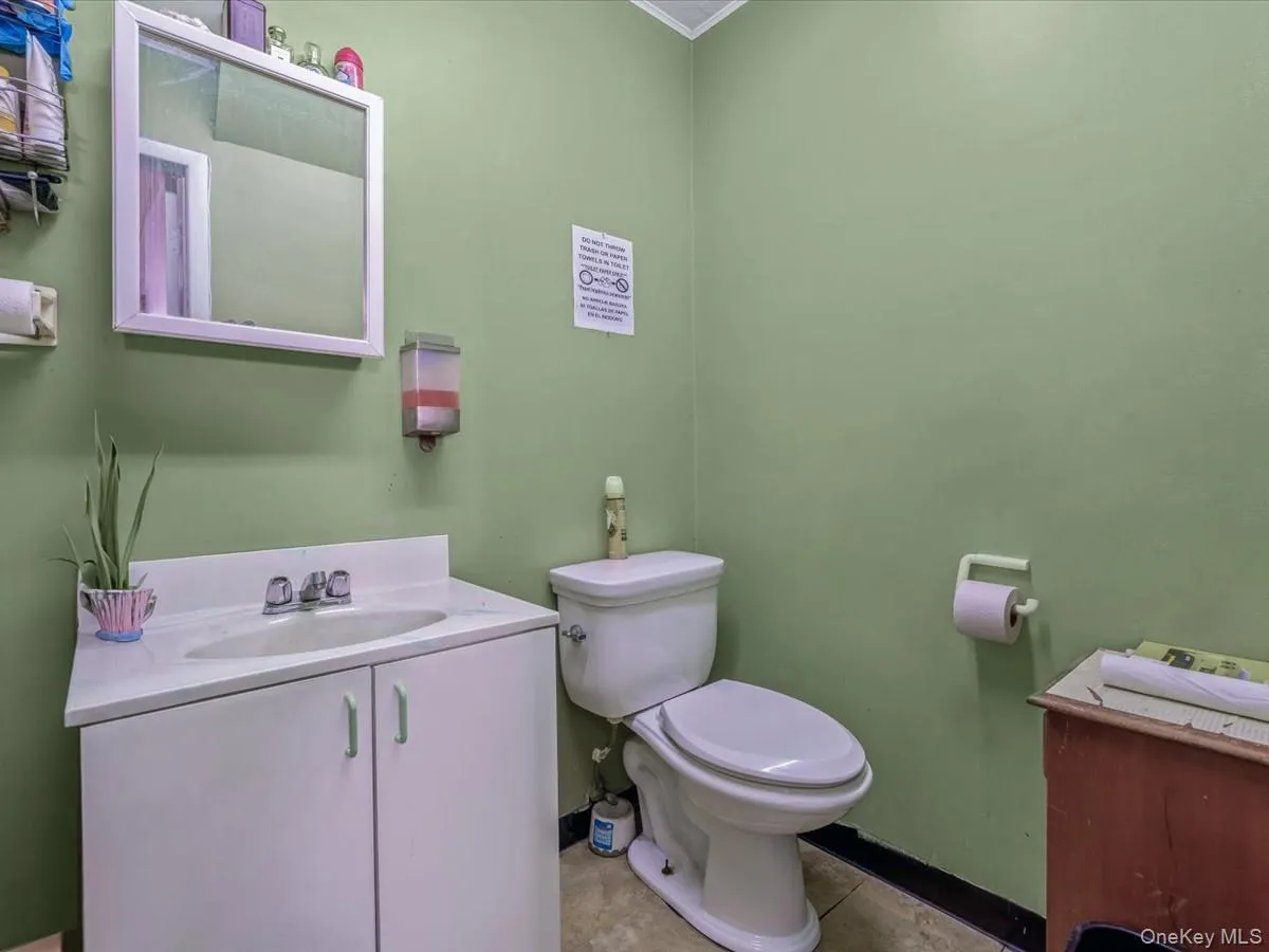 Bathroom with toilet, vanity, and baseboards Bathroom with toilet, vanity, and baseboards