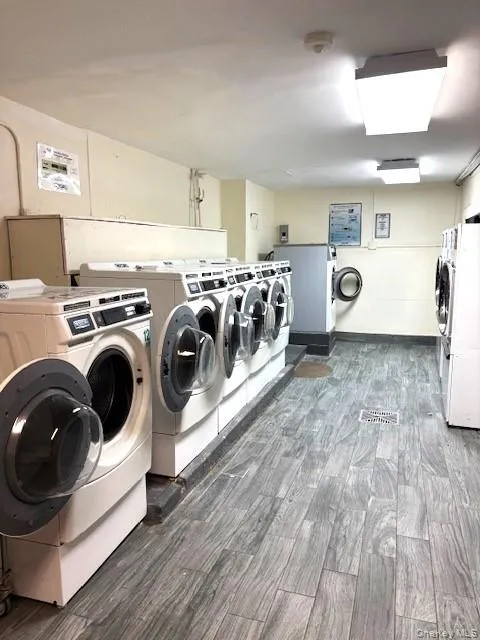Washroom featuring wood finished floors and washing machine and dryer Washroom featuring wood finished floors and washing machine and dryer